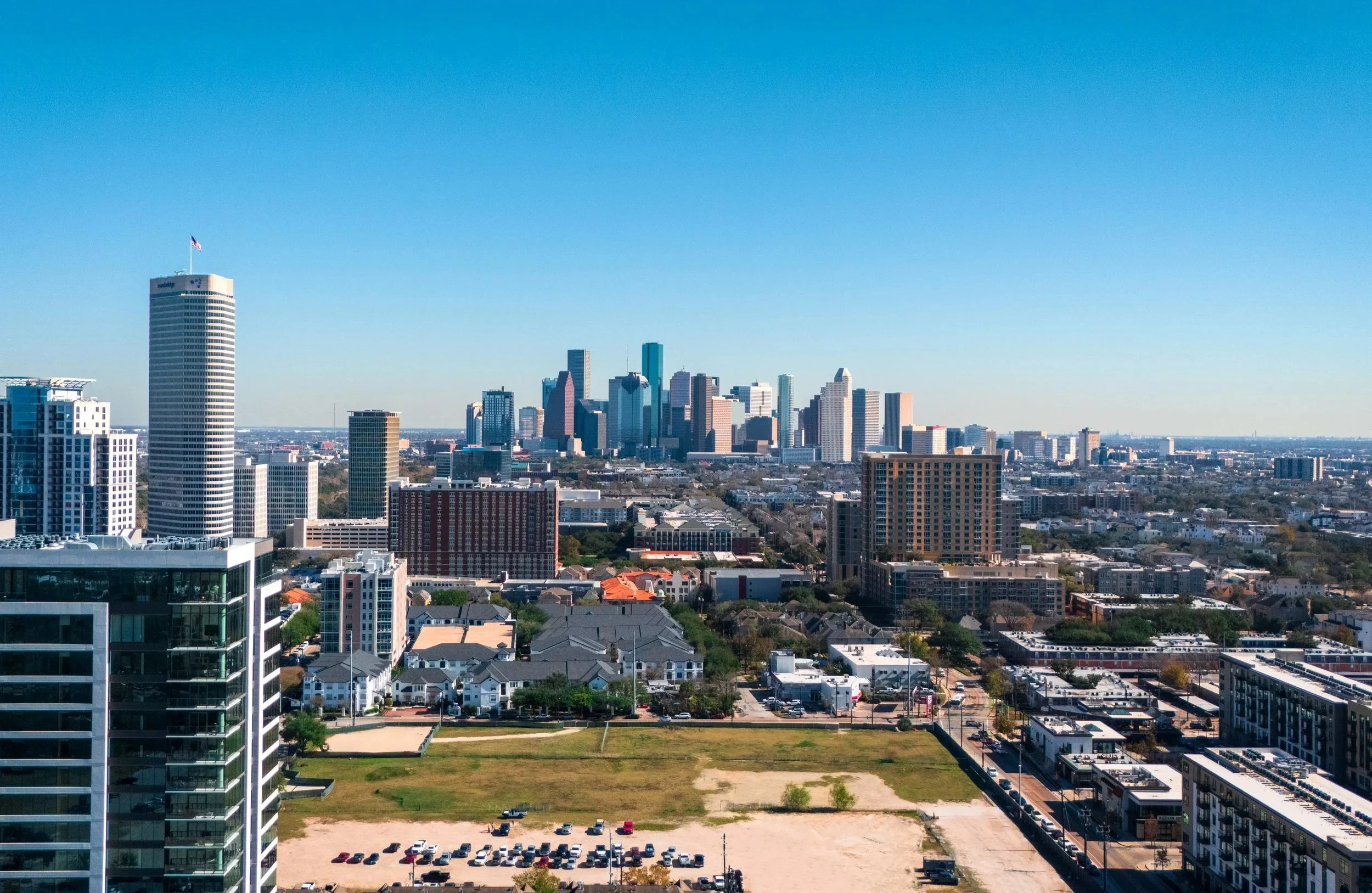 Cityscape of downtown with high-rise buildings, residential areas, and a clear blue sky.