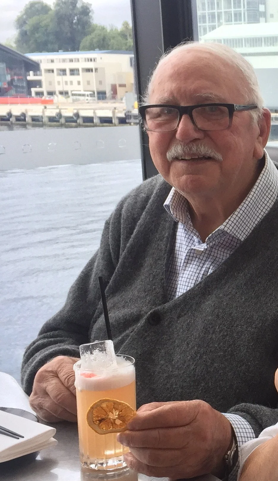 An elderly man enjoying a cocktail