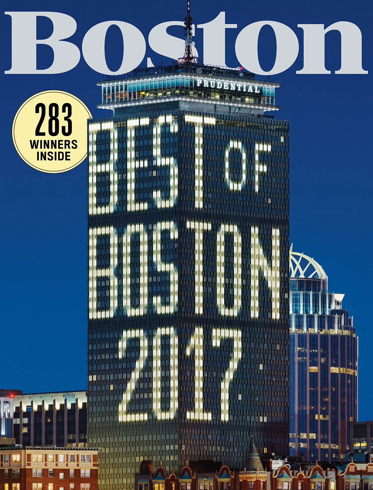 Nighttime cityscape in Boston with a tall building displaying illuminated letters and numbers reading 'BE THE 1% BET ON BOSTON 2022', and a yellow circle with '283 WINNERS INSIDE'