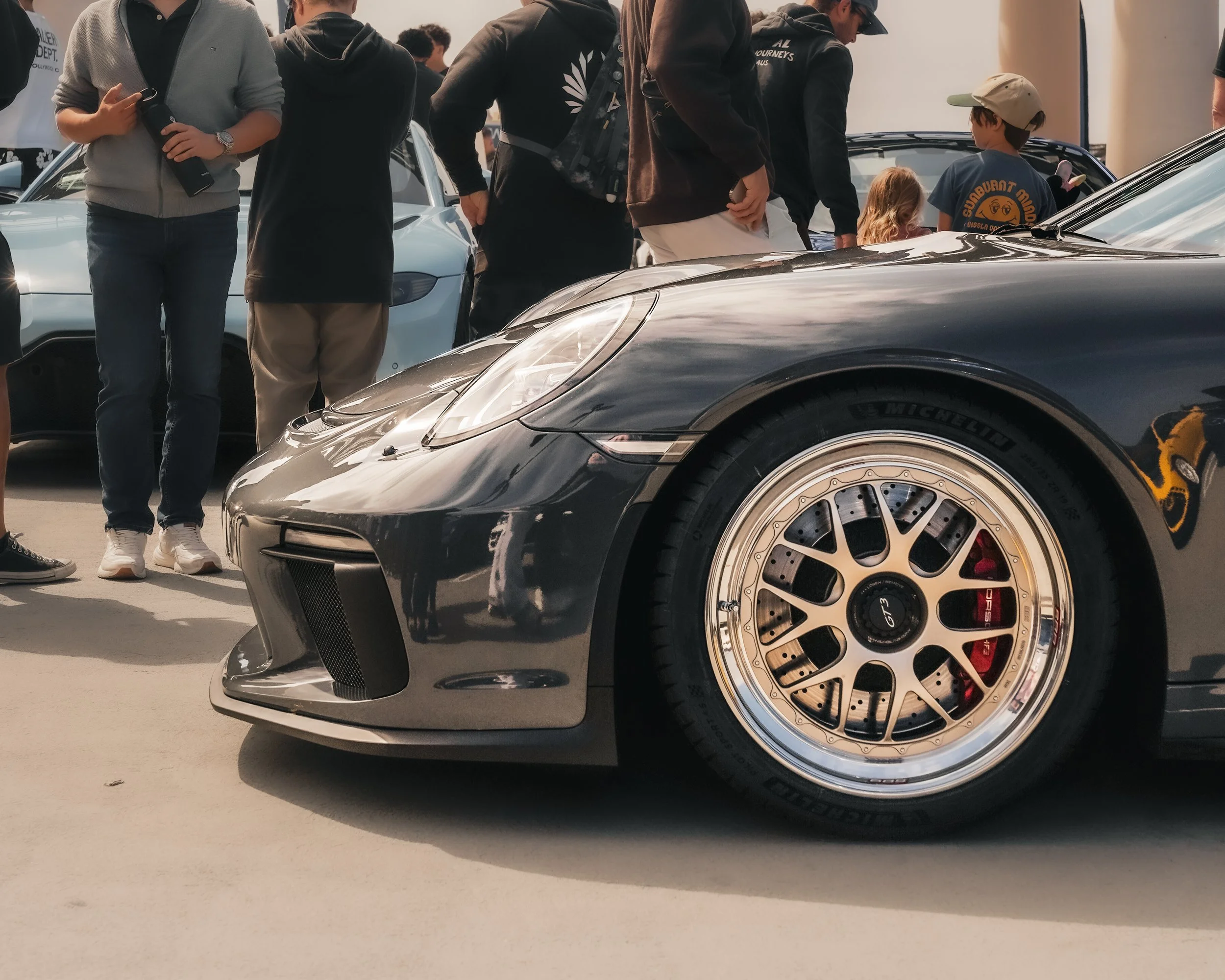 Close-up of the interior of a high-performance sports car, showing racing seats with yellow stitching and a black cap with a yellow logo placed between the seats.