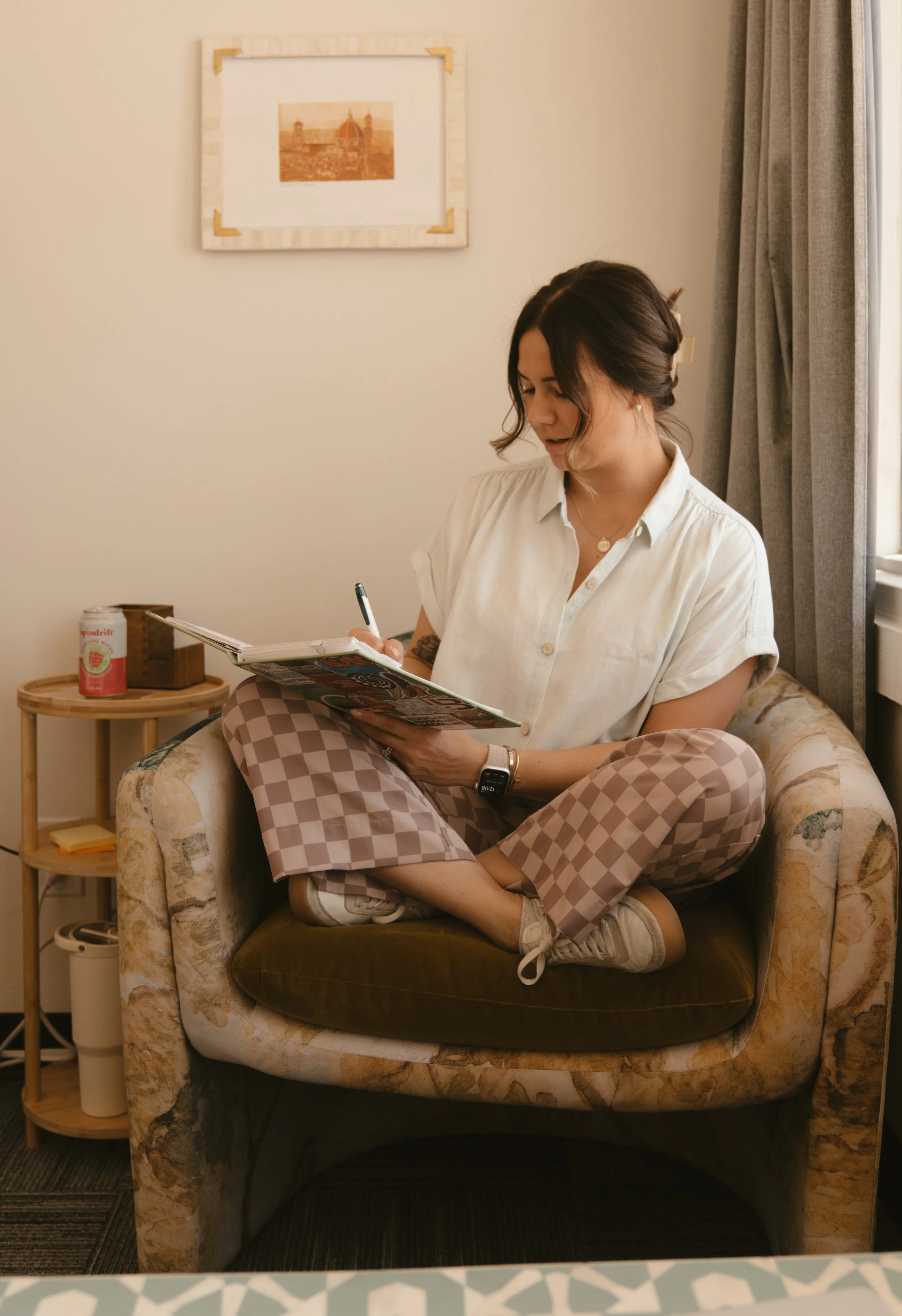 Woman sitting in chair crisscross and journaling
