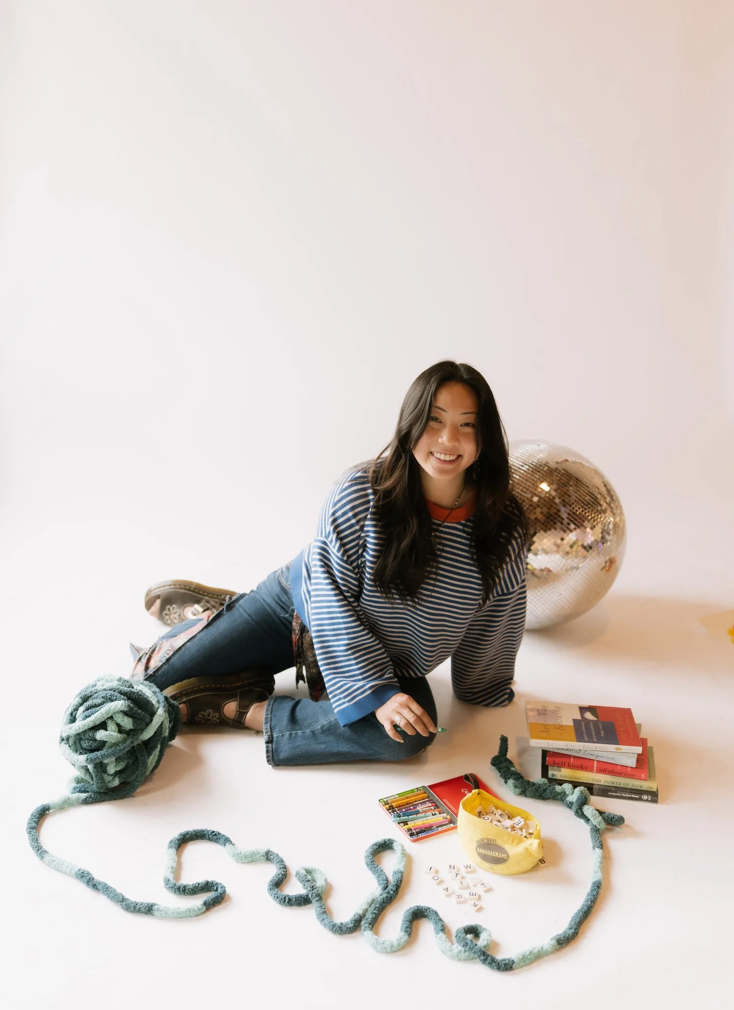 Person sitting on the floor with yarn and crayons