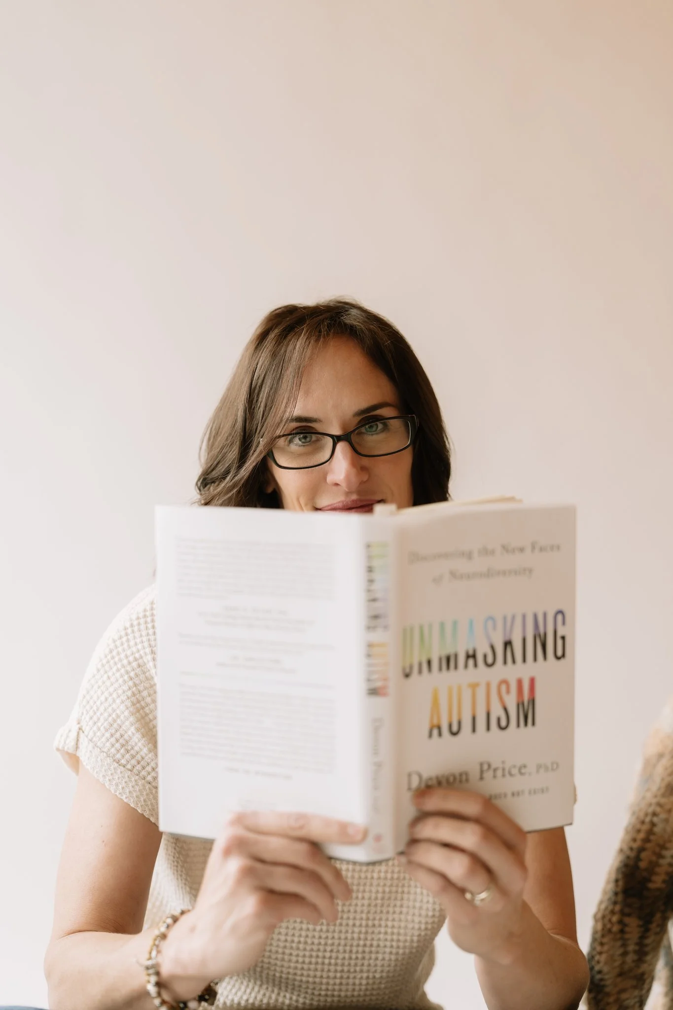 Person reading a book about unmasking autism