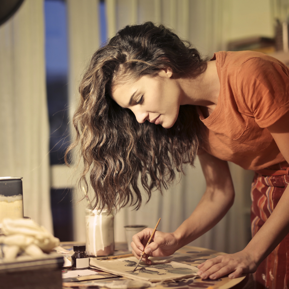 woman leaning over art and painting