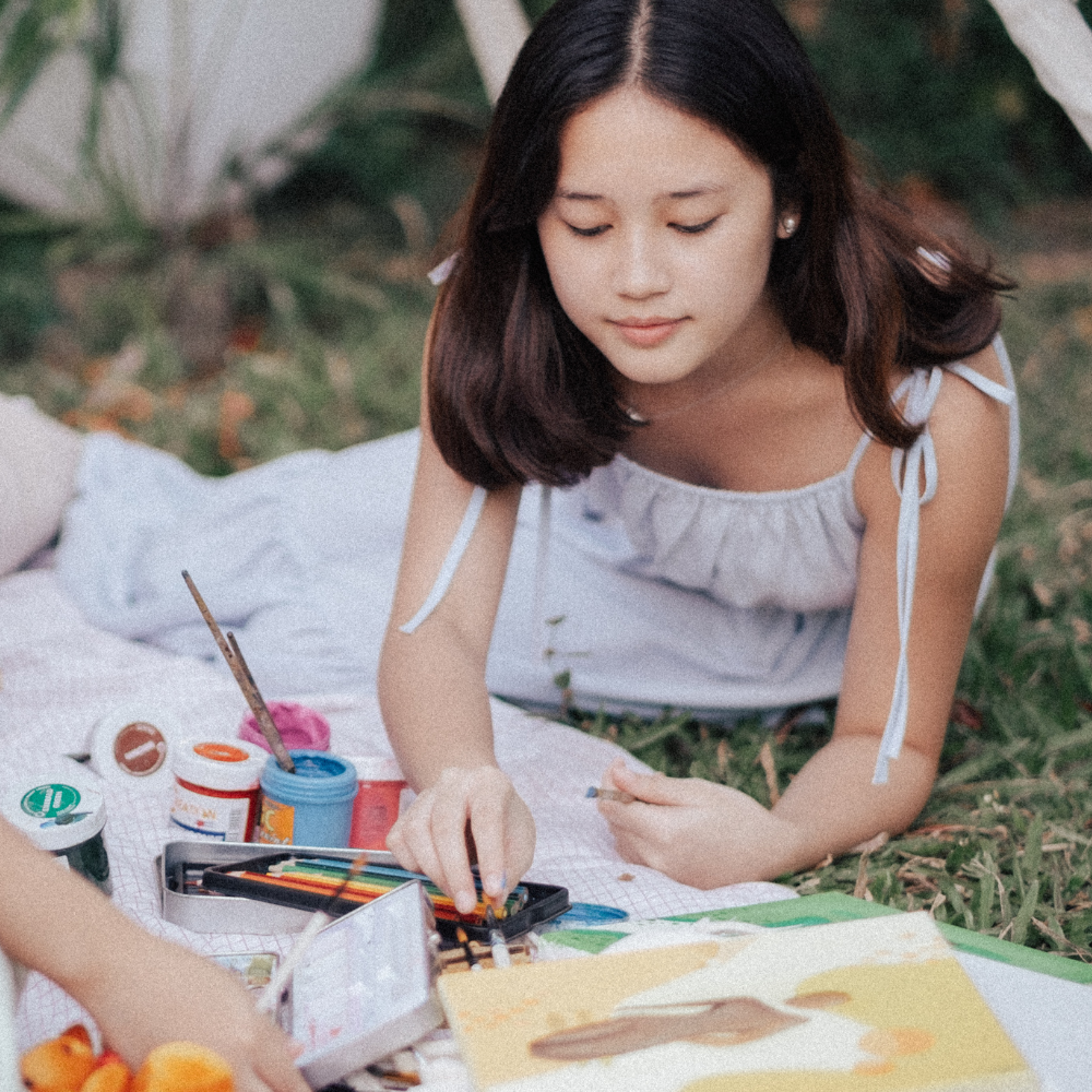 teen on grass and blanket painting and drawing