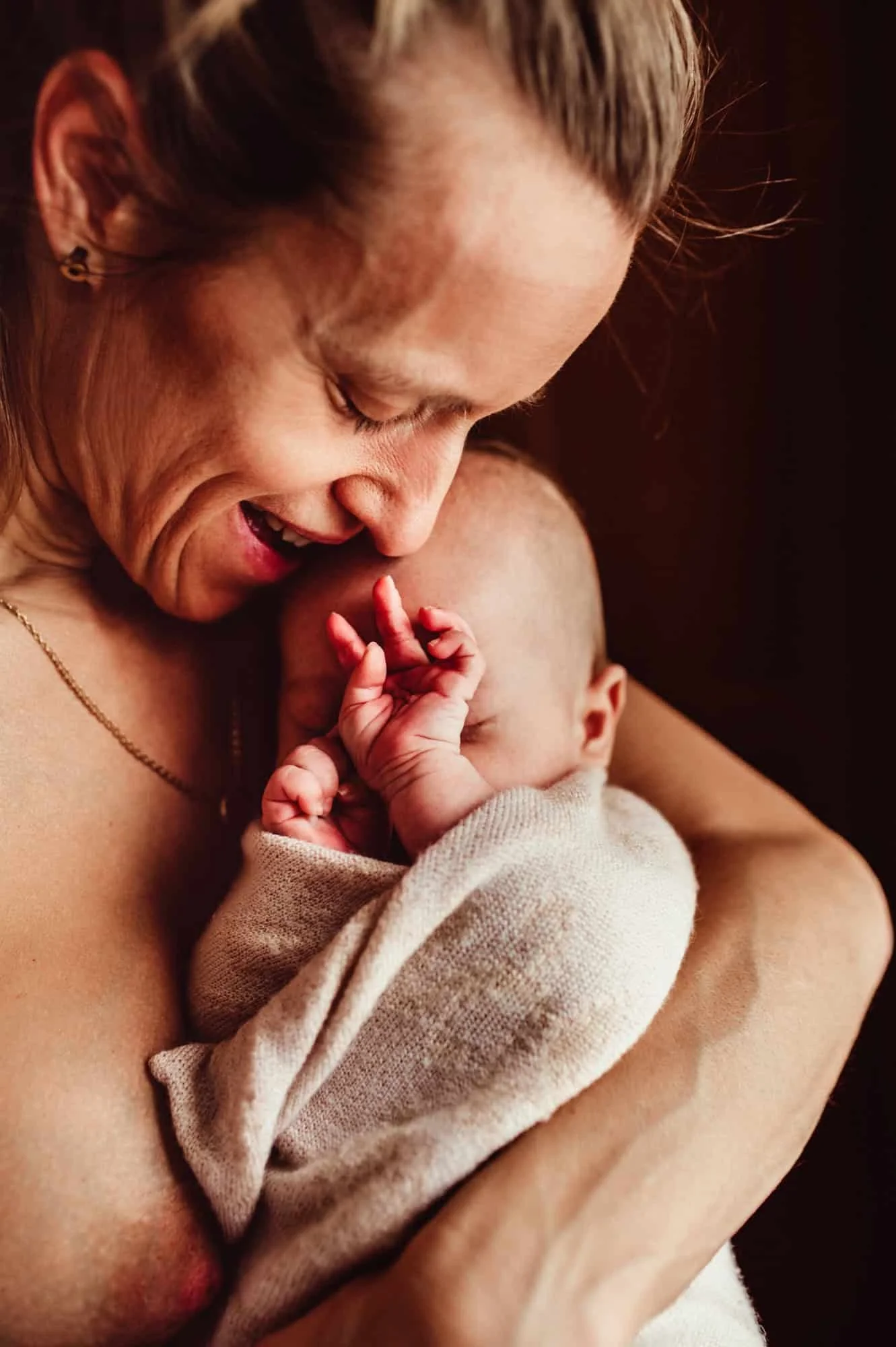 
Beste Neugeborenenfotografin in Zürich fotografiert eine Mama mit ihrem Baby am Fenster, eingefangen in einer ruhigen und intimen Atmosphäre