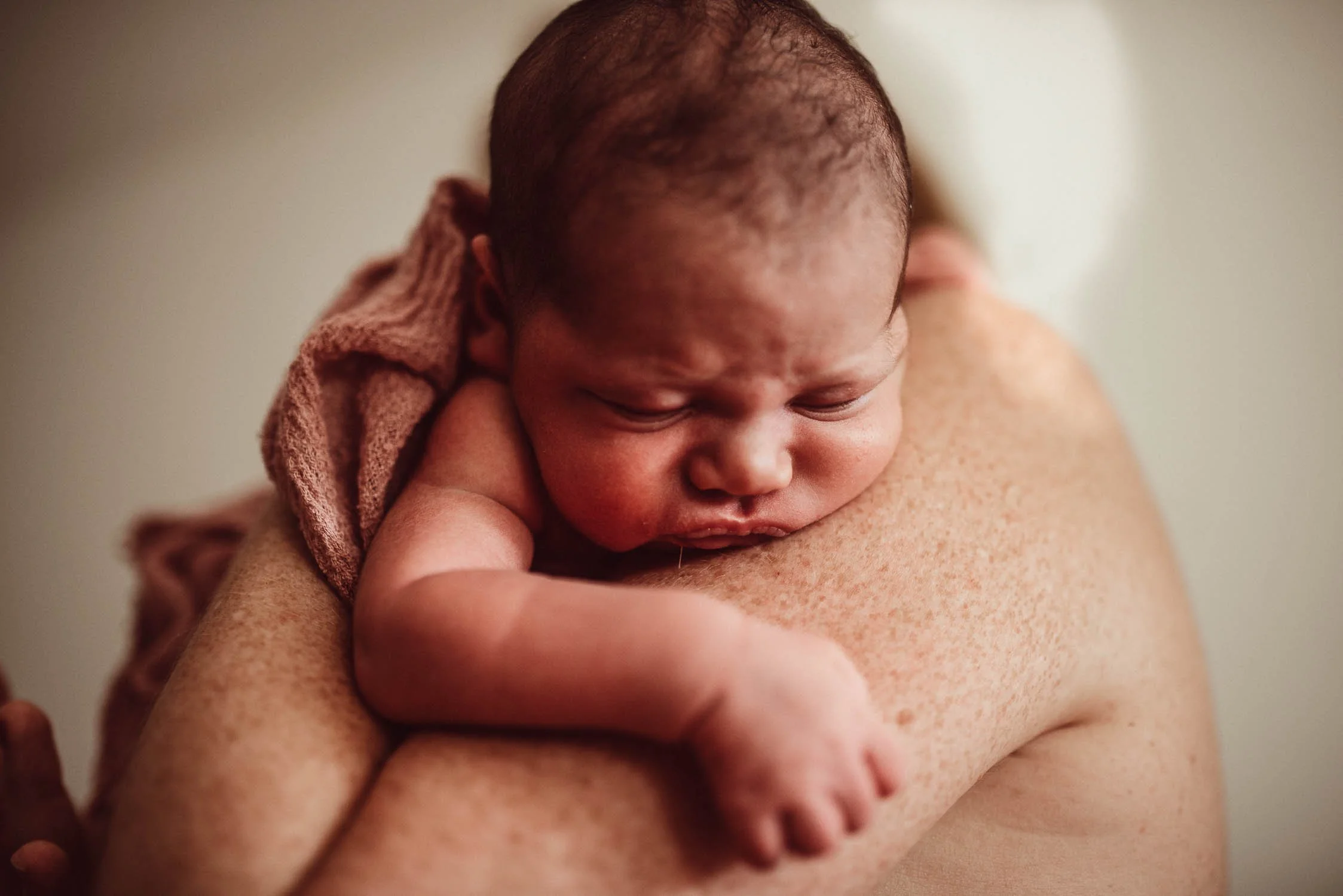 Liebevoller Moment zwischen Mutter und Neugeborenem zur Förderung der Bindung im Wochenbett. 