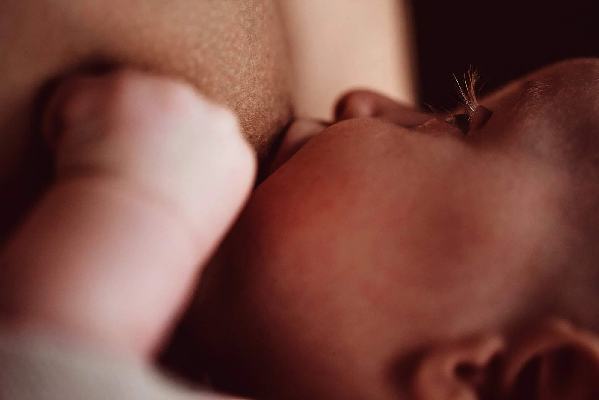 Nursing baby in a tender moment, captured by the best newborn photographer in Zürich, highlighting the bond between mother and child