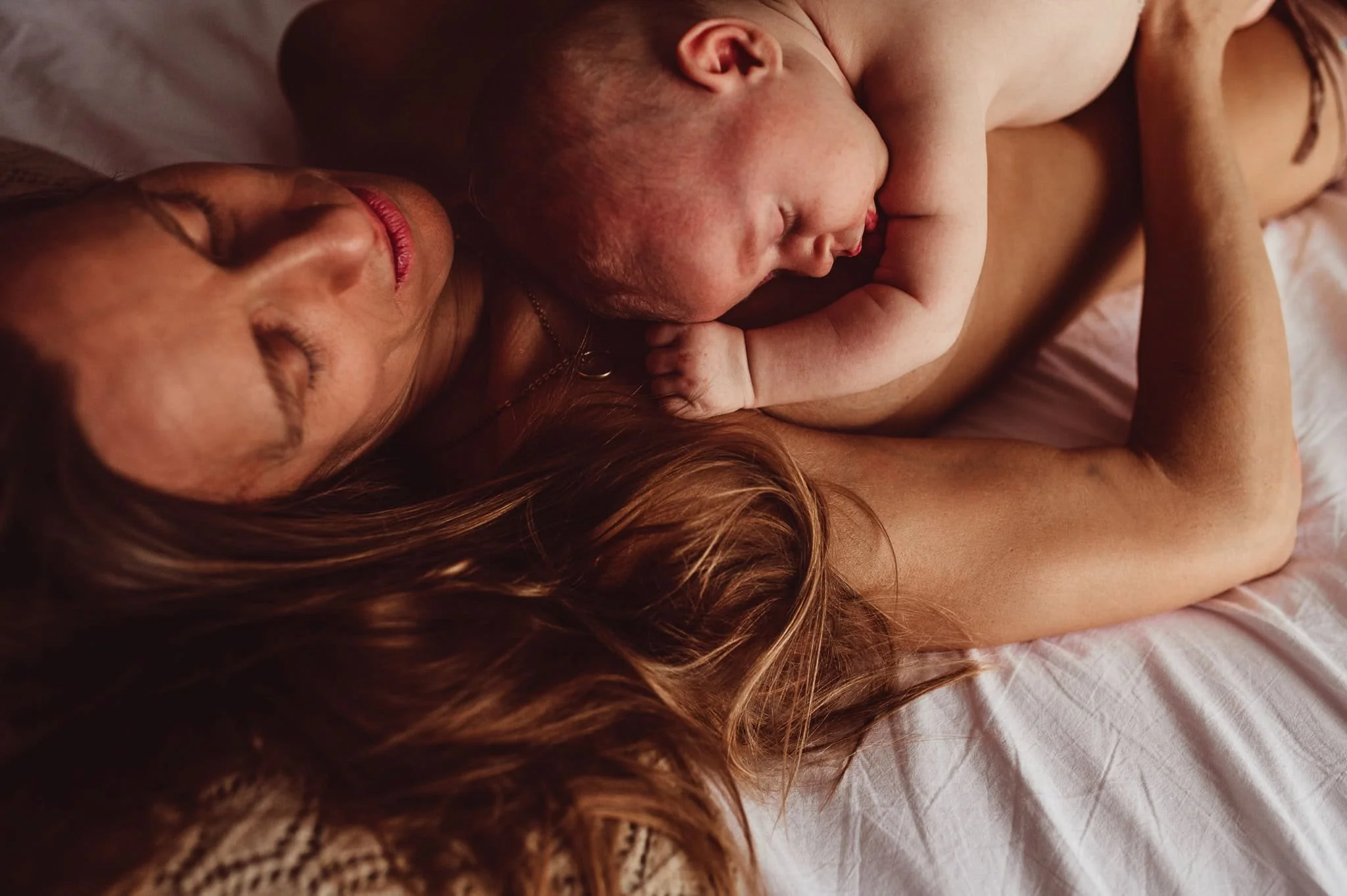 Inniger Moment des Bondings durch direkten Hautkontakt zwischen Mutter und Kind in den ersten Wochen nach der Geburt