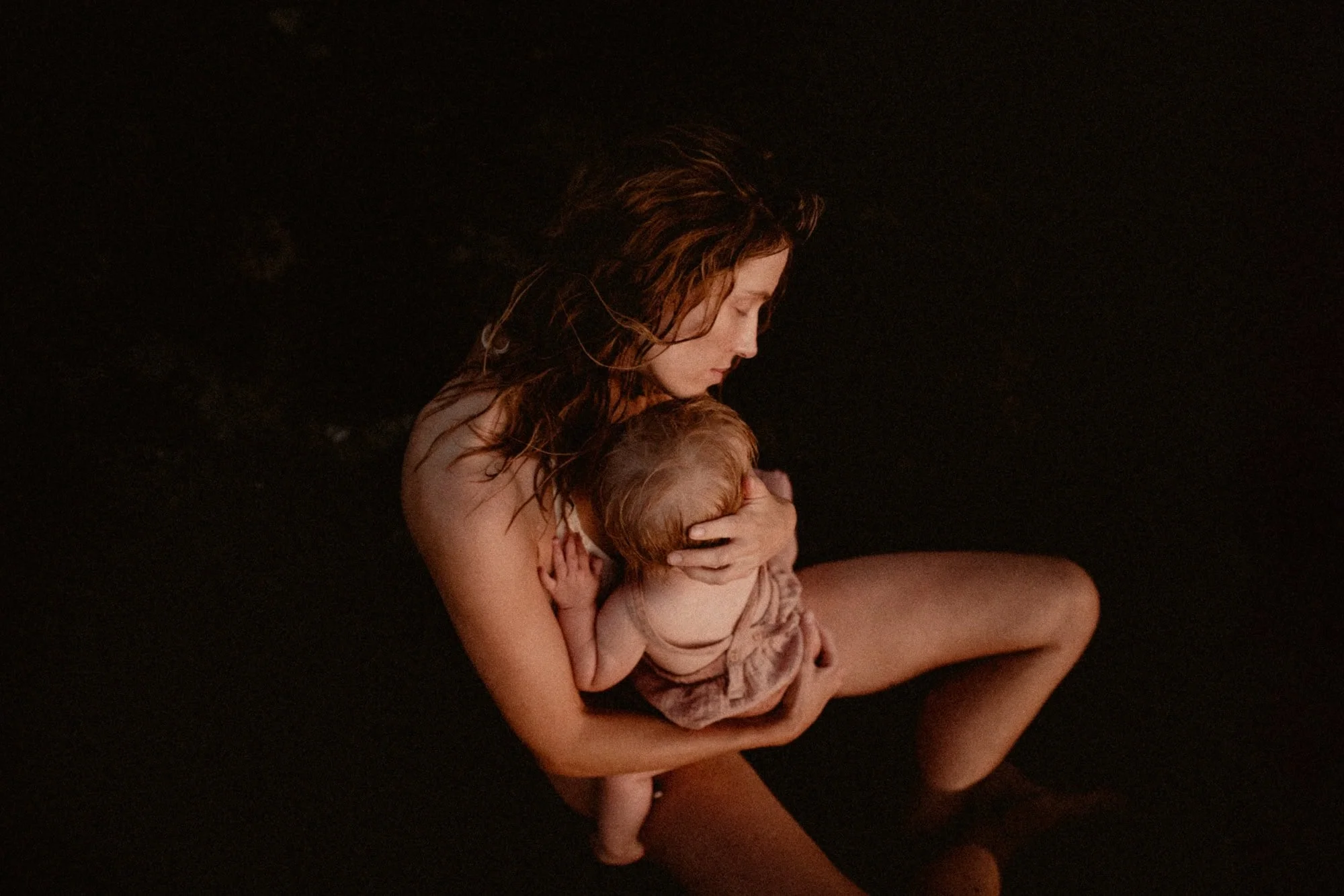 Motherhood photographer captures a tender moment of a mother holding her child close, showcasing love, connection, and intimacy