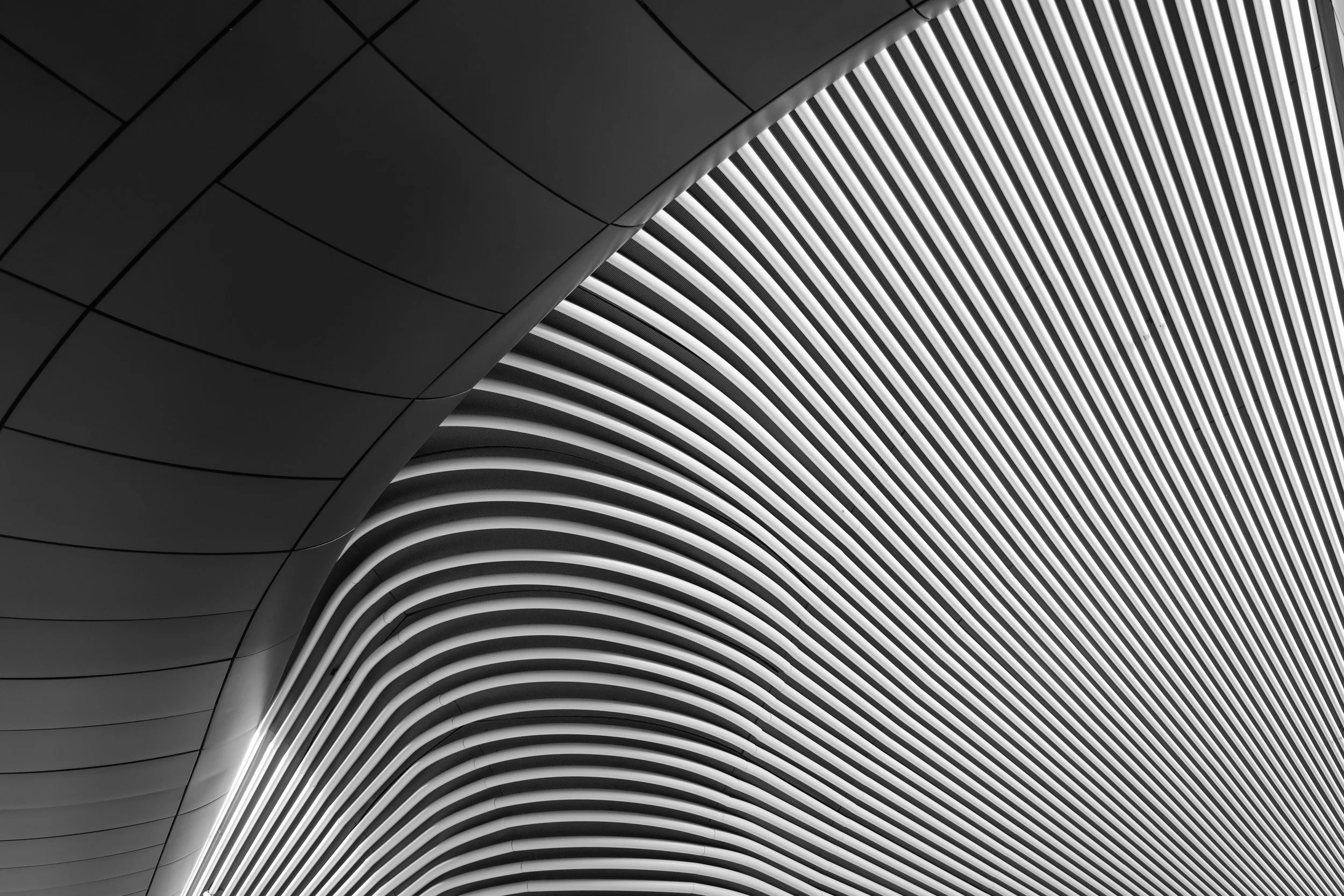Close-up of modern architectural design featuring curved black and white striped patterns and smooth surfaces.