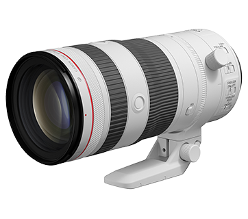 White telephoto camera lens with black rings and zoom or focus adjustment rings, mounted on a white tripod.