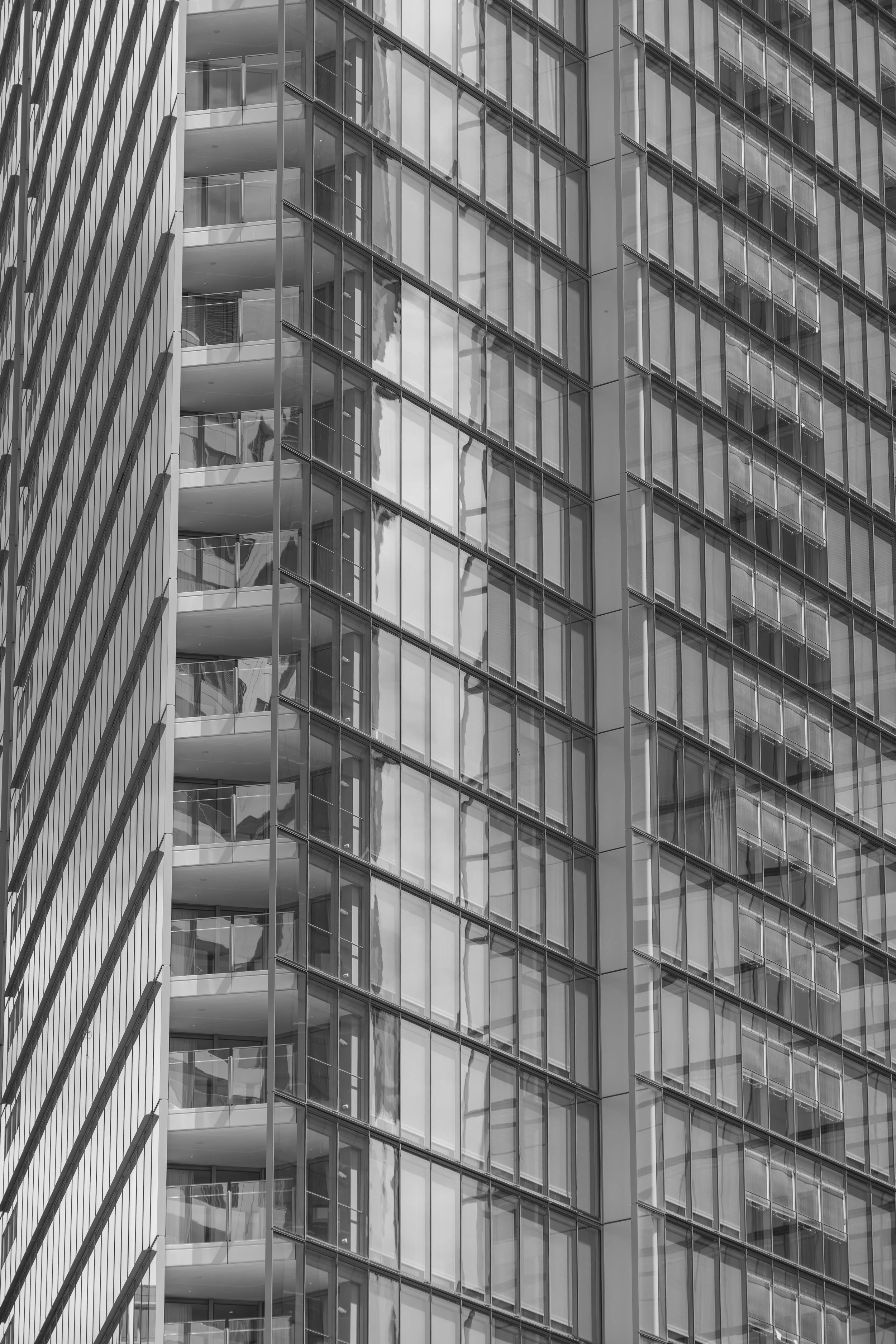 Close-up view of a modern high-rise building with glass windows and balconies.