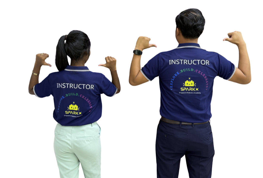 Two instructors, a woman and a man, are standing side by side with their backs to the camera, flexing their arm muscles. They are wearing blue polo shirts with the word 'INSTRUCTOR' and a logo for Singapore Robotics Academy on the back.