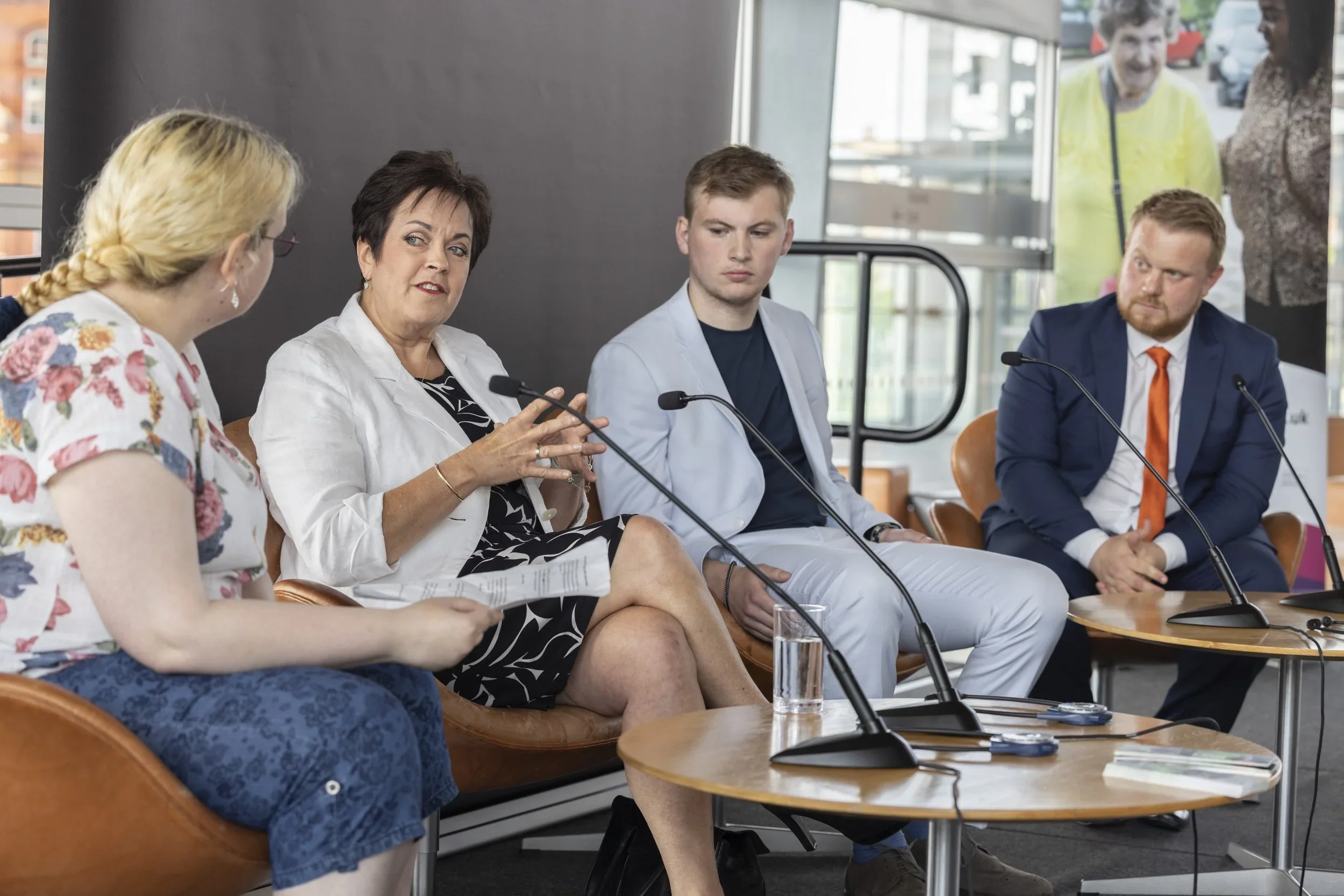Rob Osborne chairing a panel discussion, guiding debate with speakers in the Senedd.