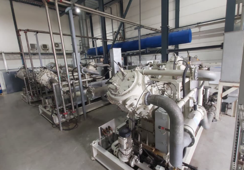 Industrial refrigeration compressor system with large pipes and machinery inside a mechanical plant