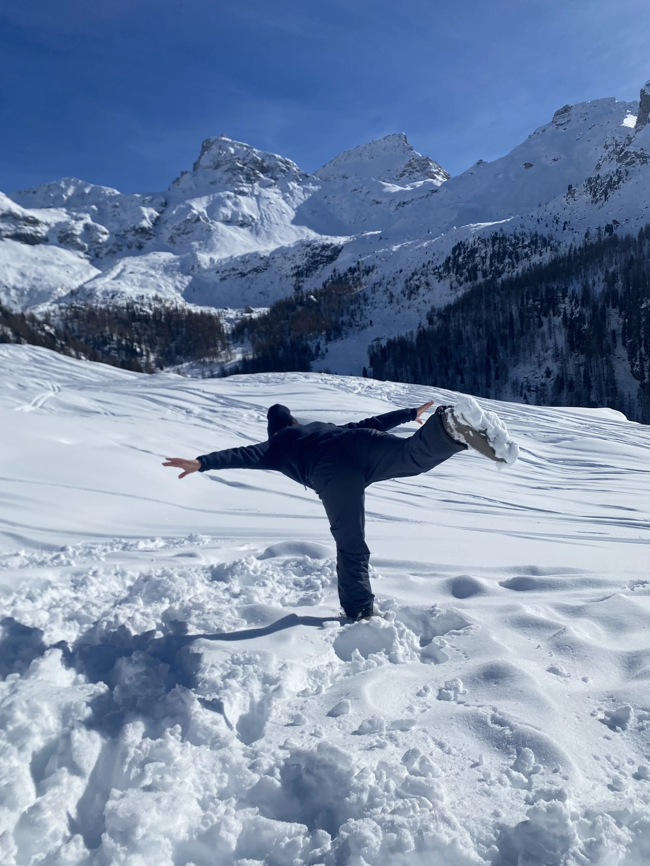 skiandyogaretreat in Italian Alps - women doing a balancing yoga position in the snow