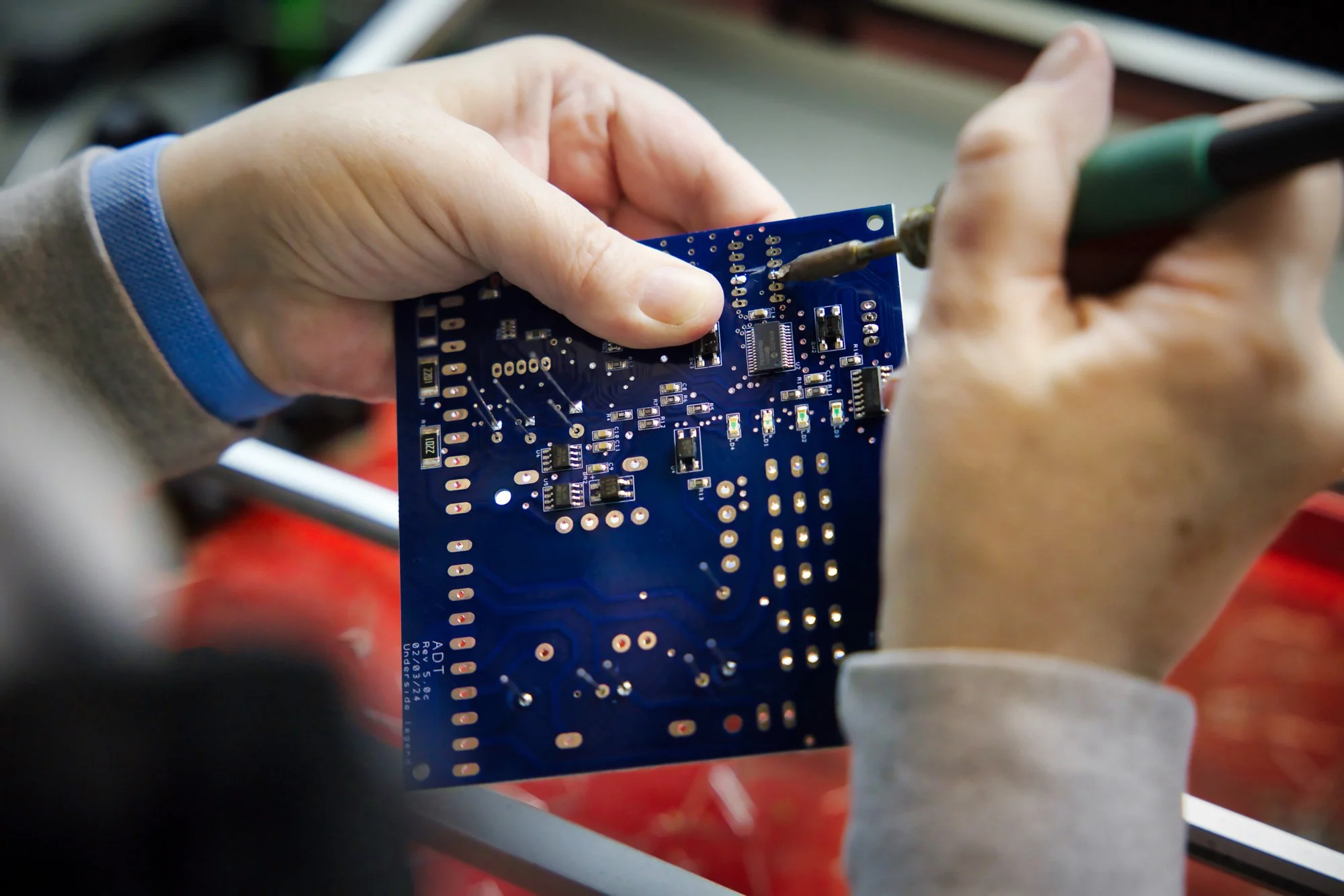 PCB Assembly shown by someone soldering a through-hole assembly board