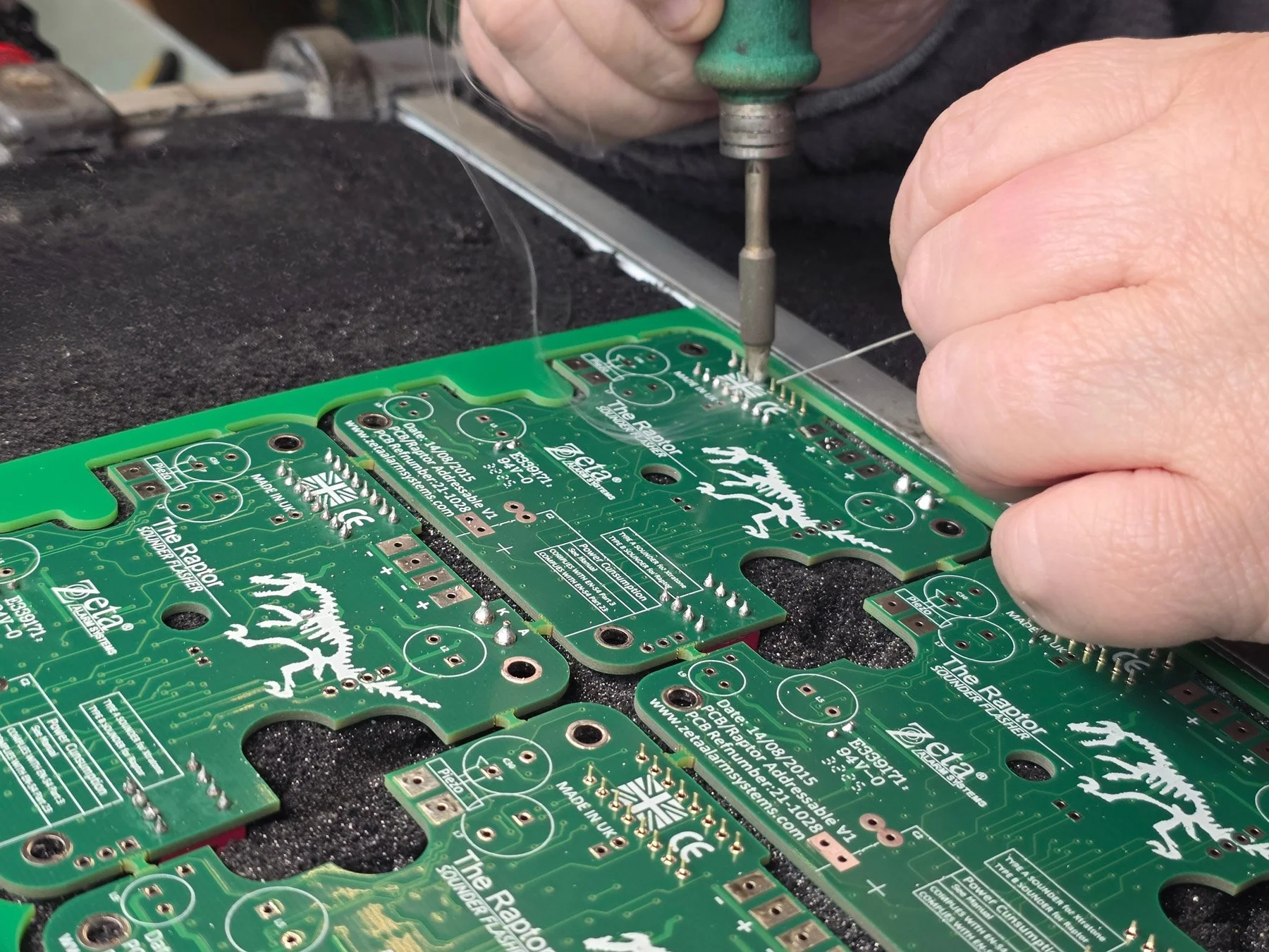 PCB Assembly shown by someone soldering a through-hole assembly board