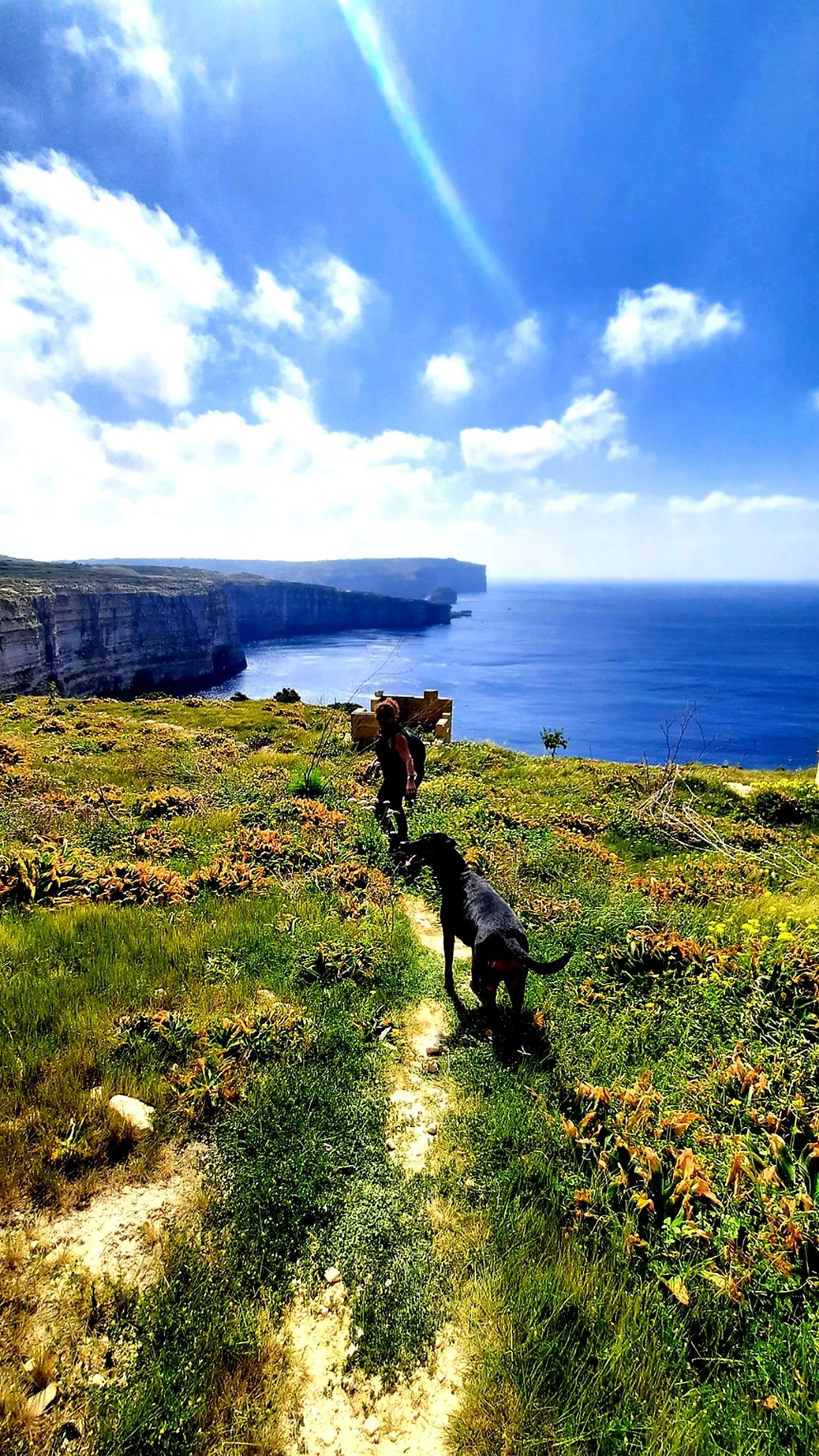 Jacqui and Freya in distance Walking along cliffs Gozo.jpg
