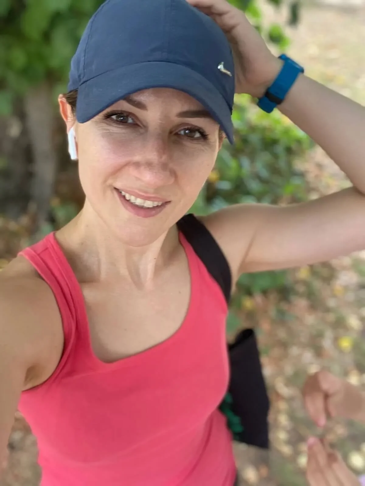 Eliza smiling wearing a navy blue baseball cap