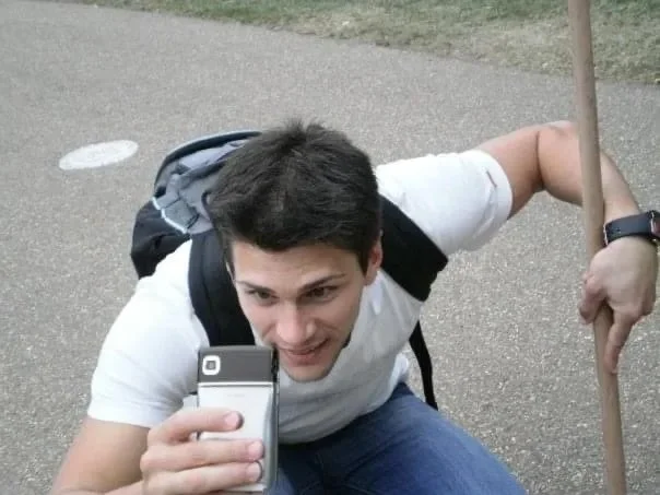 Silviu crouching down taking a picture with a phone