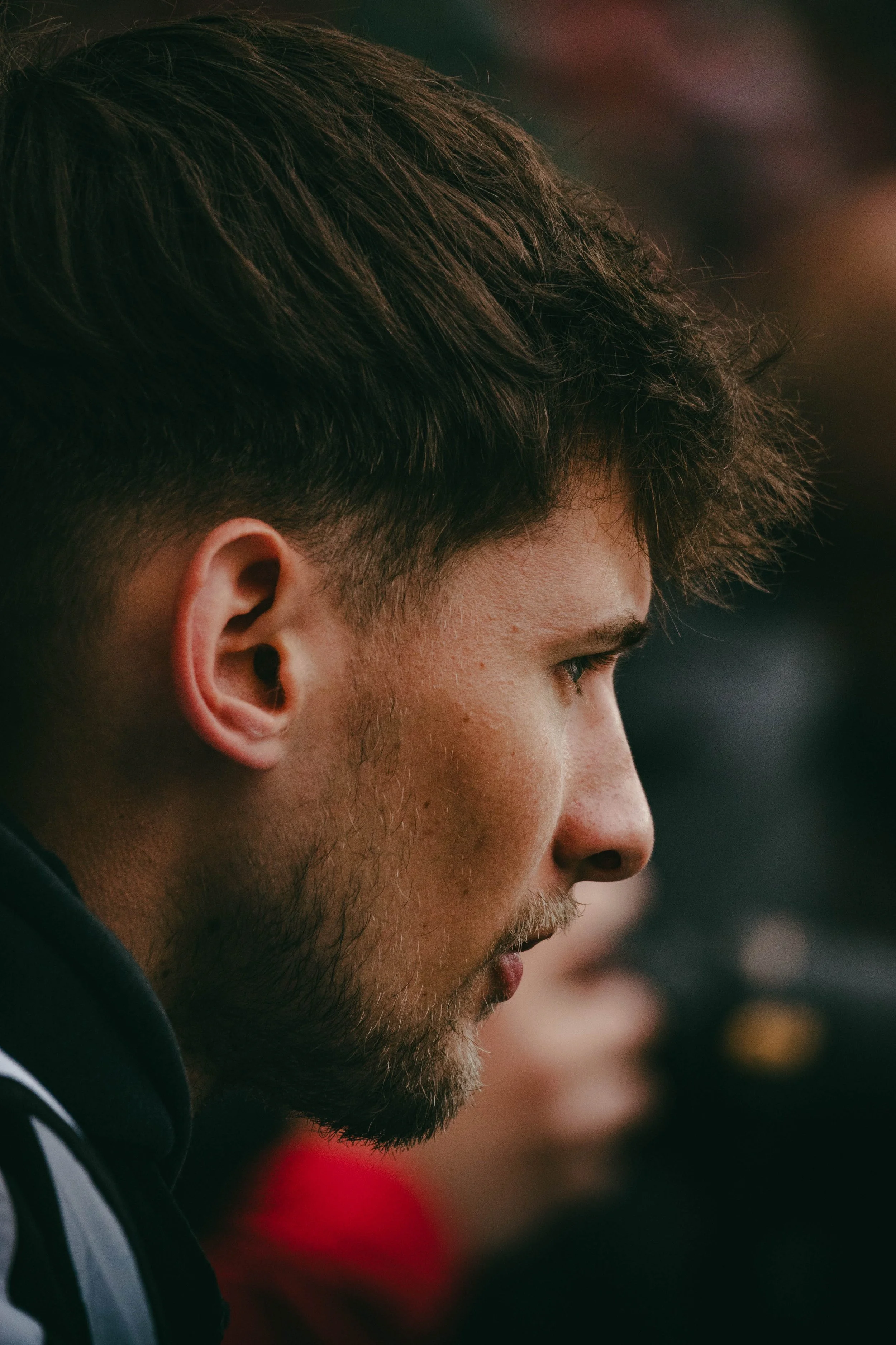 Nahaufnahme von Sportfotograf Lennard Stefke, der zur Seite schaut.
