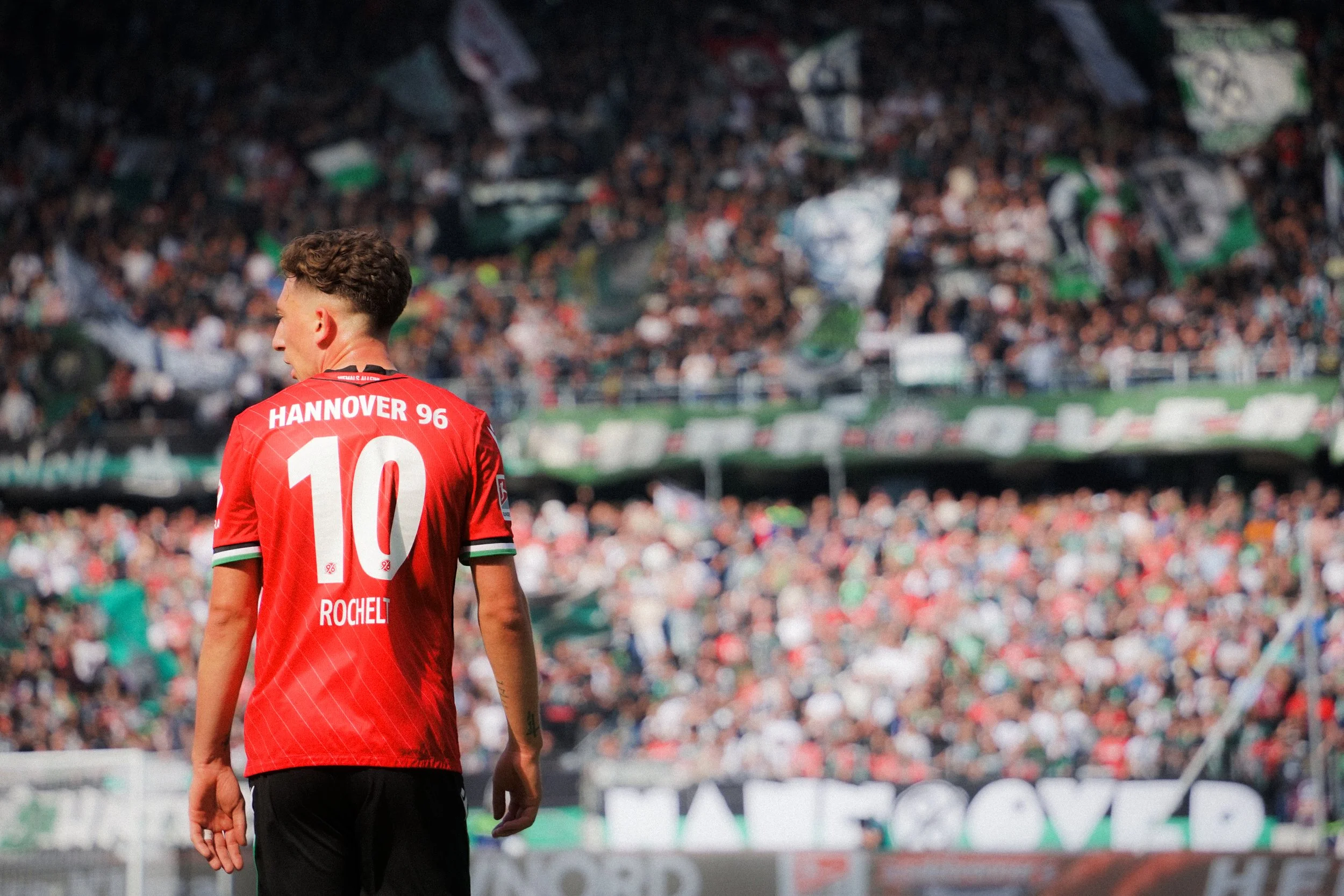 Fußballspieler in rotem Trikot von Hannover 96 mit der Nummer 10 auf dem Spielfeld.