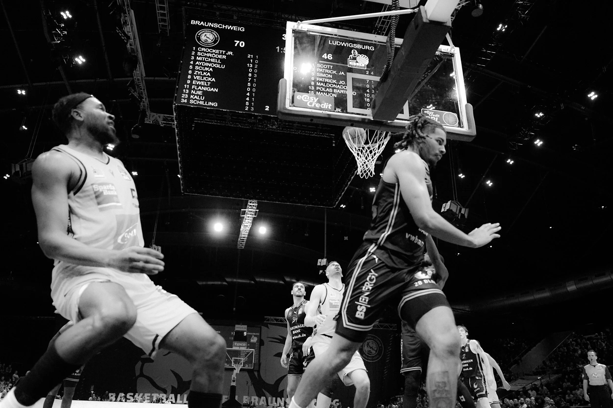 Basketballspiel mit Spielern, schwarzes und weißes Bild, Anzeigetafel mit Punktestand Braunschweig 70, Ludwigsburg 46.