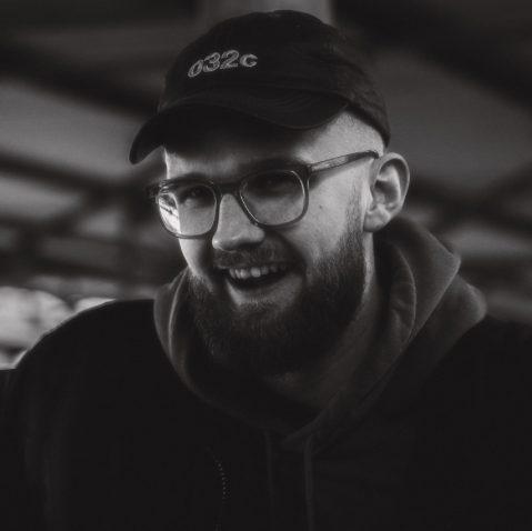Cedrik Rott, trägt eine Kappe und lächelt, in Schwarz-Weiß-Fotografie.