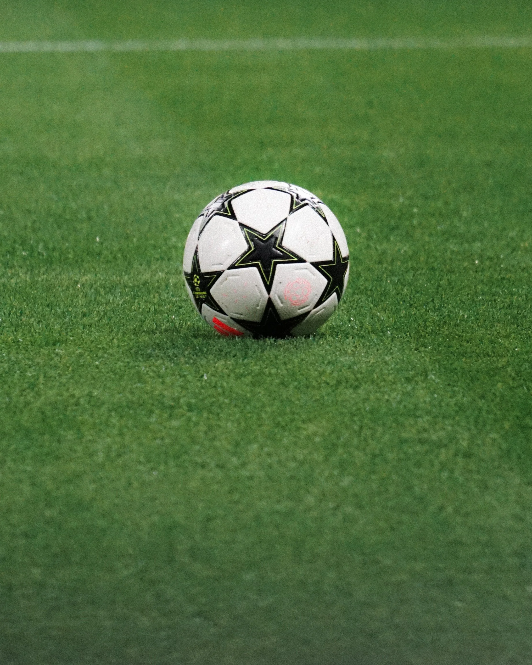Ein Fußball auf einem grünen Rasen.
