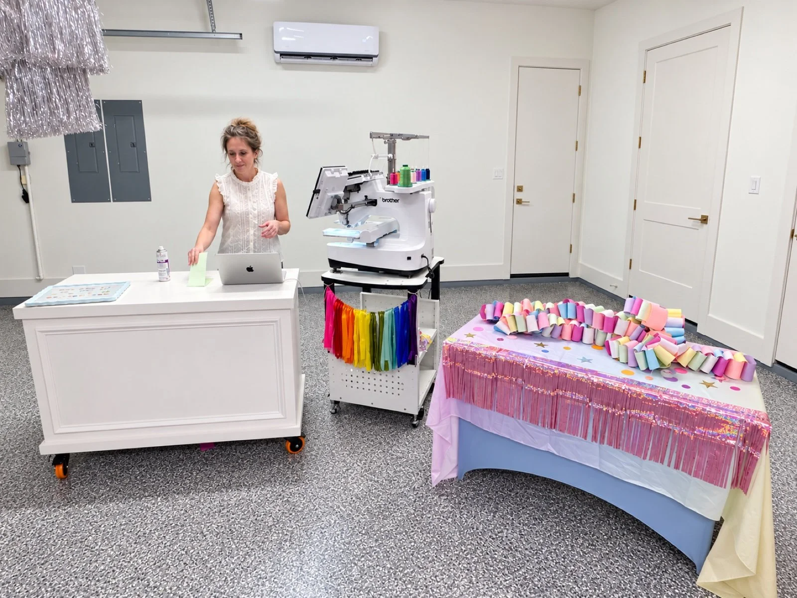 Allison at the live embroidery station at Blakely’s party, with the full machine and upper thread assembly visible.
