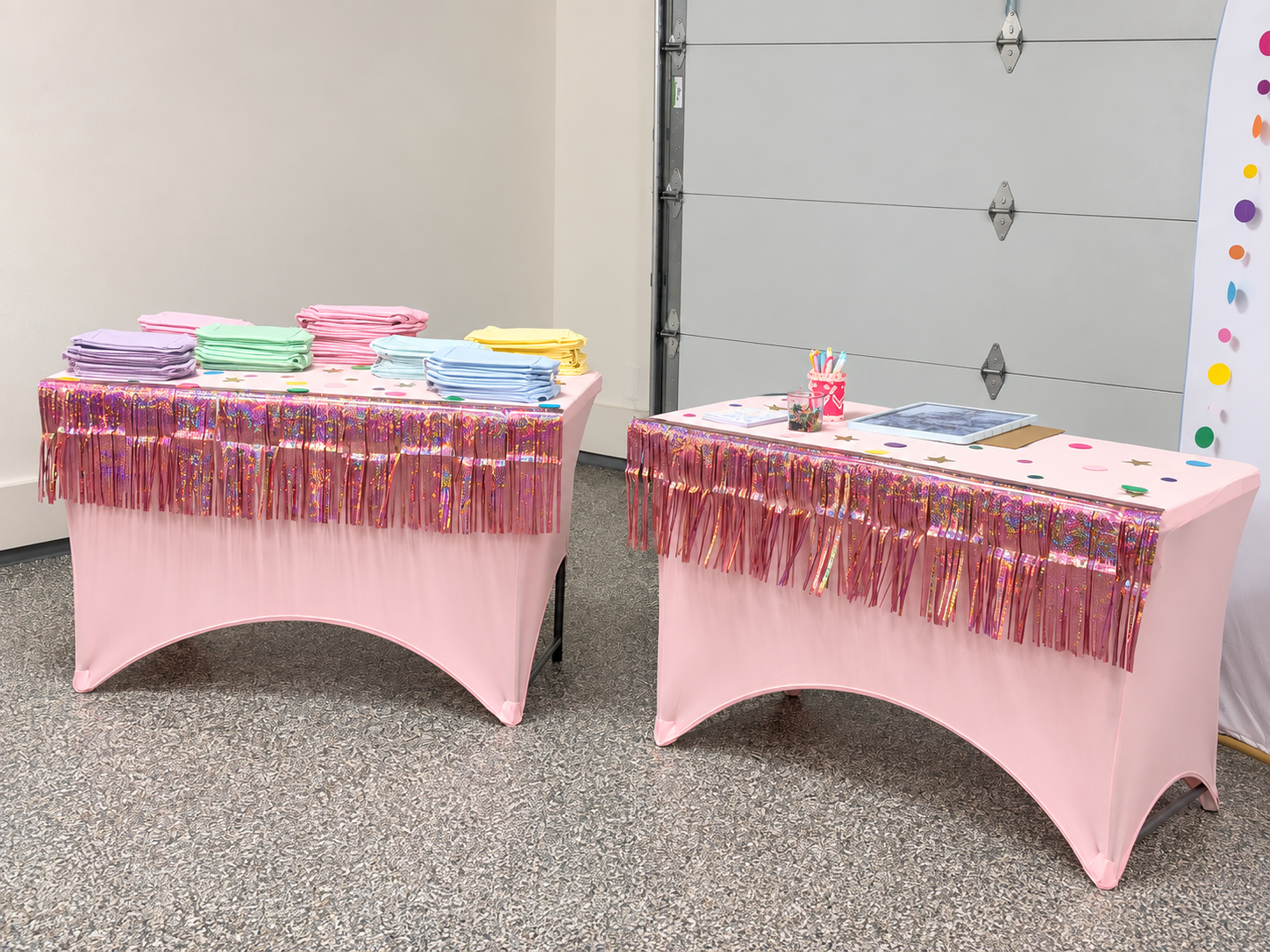 Pastel pouches and menu cards arranged on pink tables for guests at Blakely’s live embroidery party.