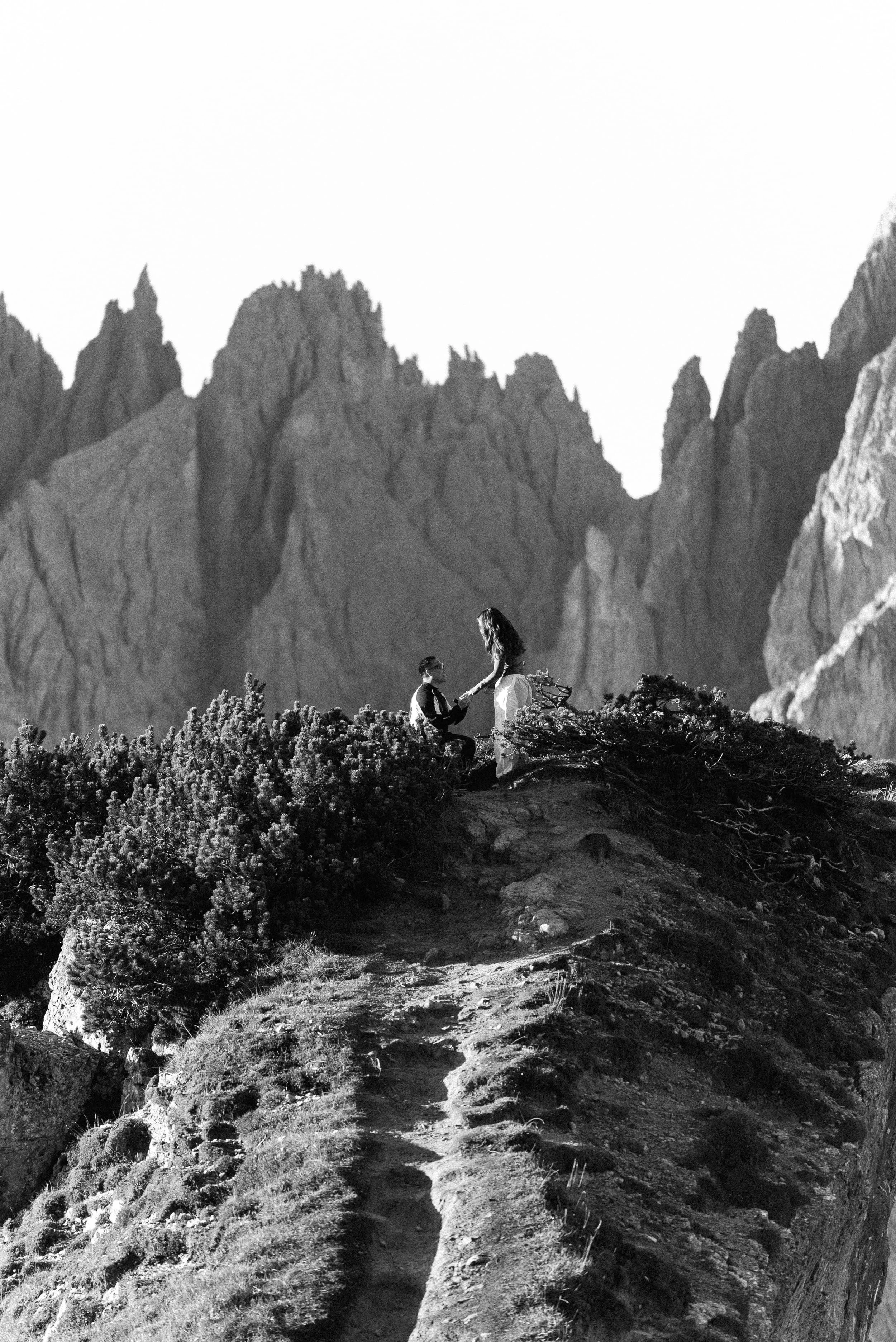Surprise proposal at sunrise overlooking Cadini di Misurina in the Dolomites, Italy.