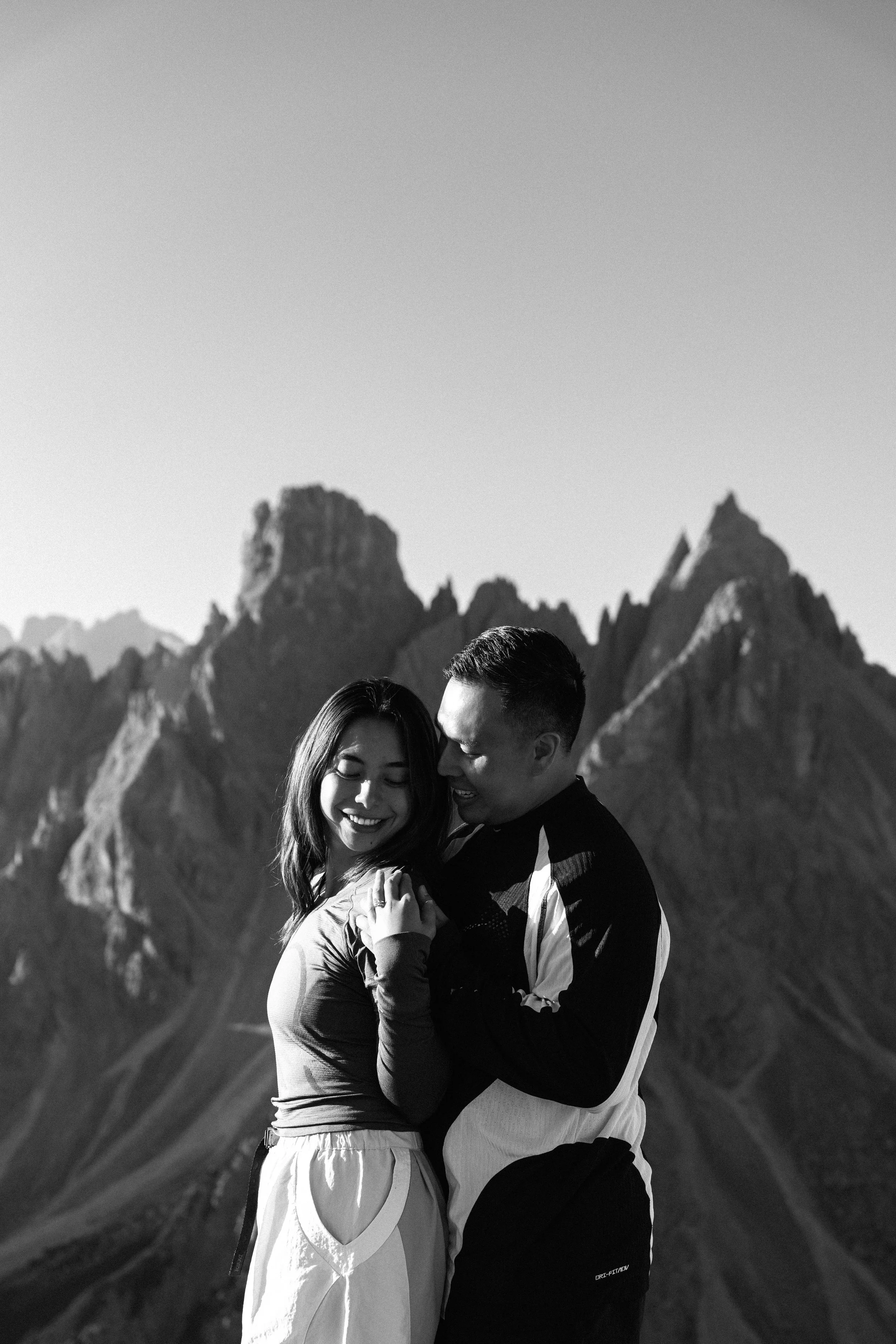 Intimate surprise proposal photographed against a mountain landscape in the Italian Dolomites.
