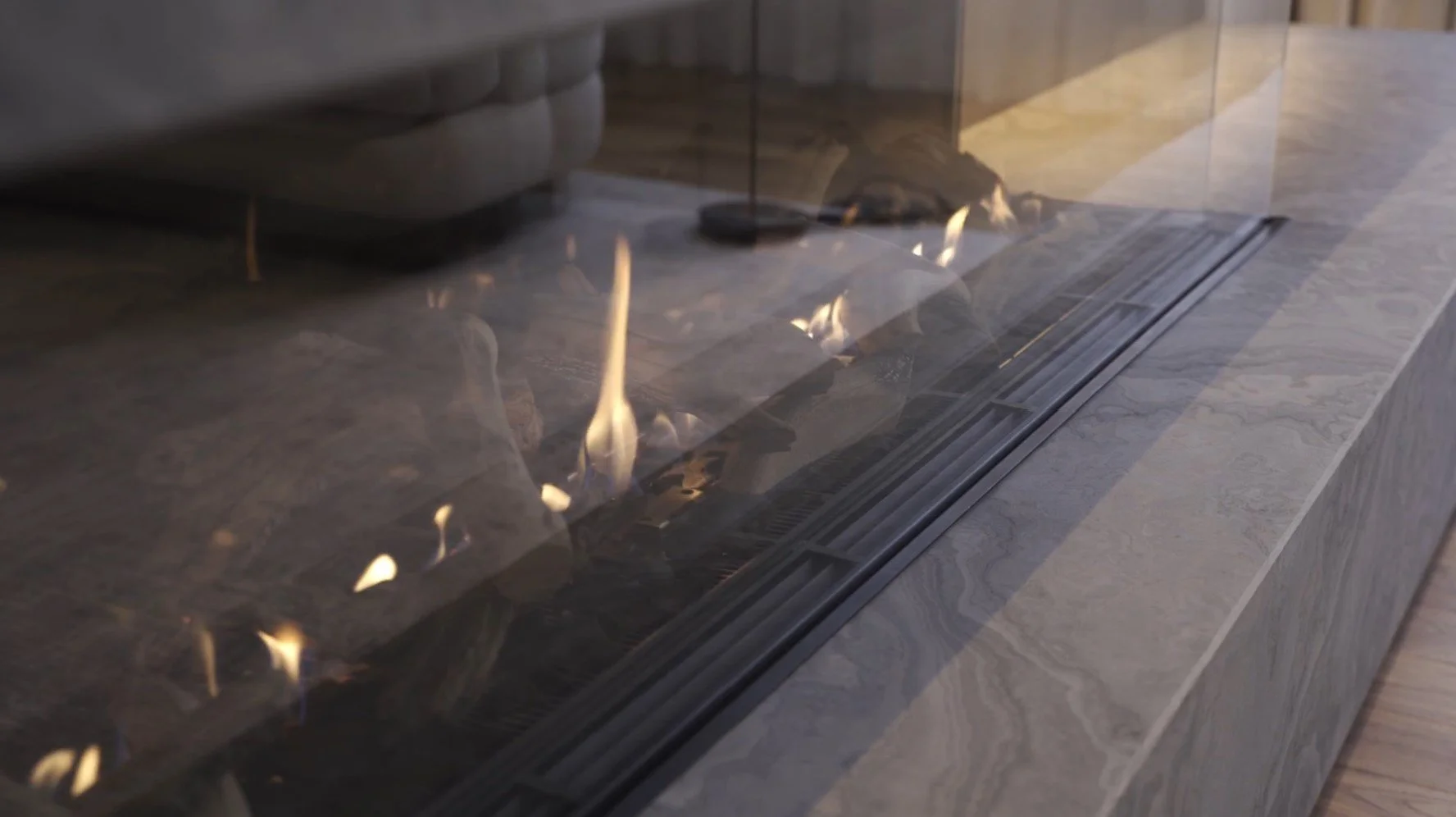 Modern indoor gas fireplace with glass enclosure and visible flames.