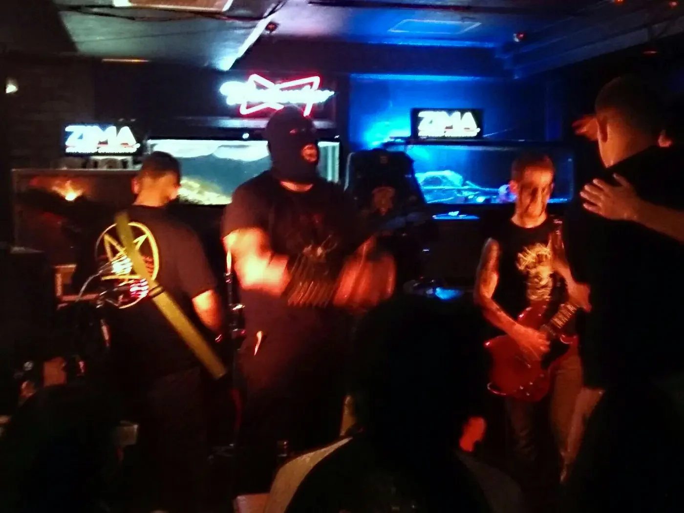 Darkcorpse on stage delivering a fast, abrasive raw black metal set driven by guitar and drums.