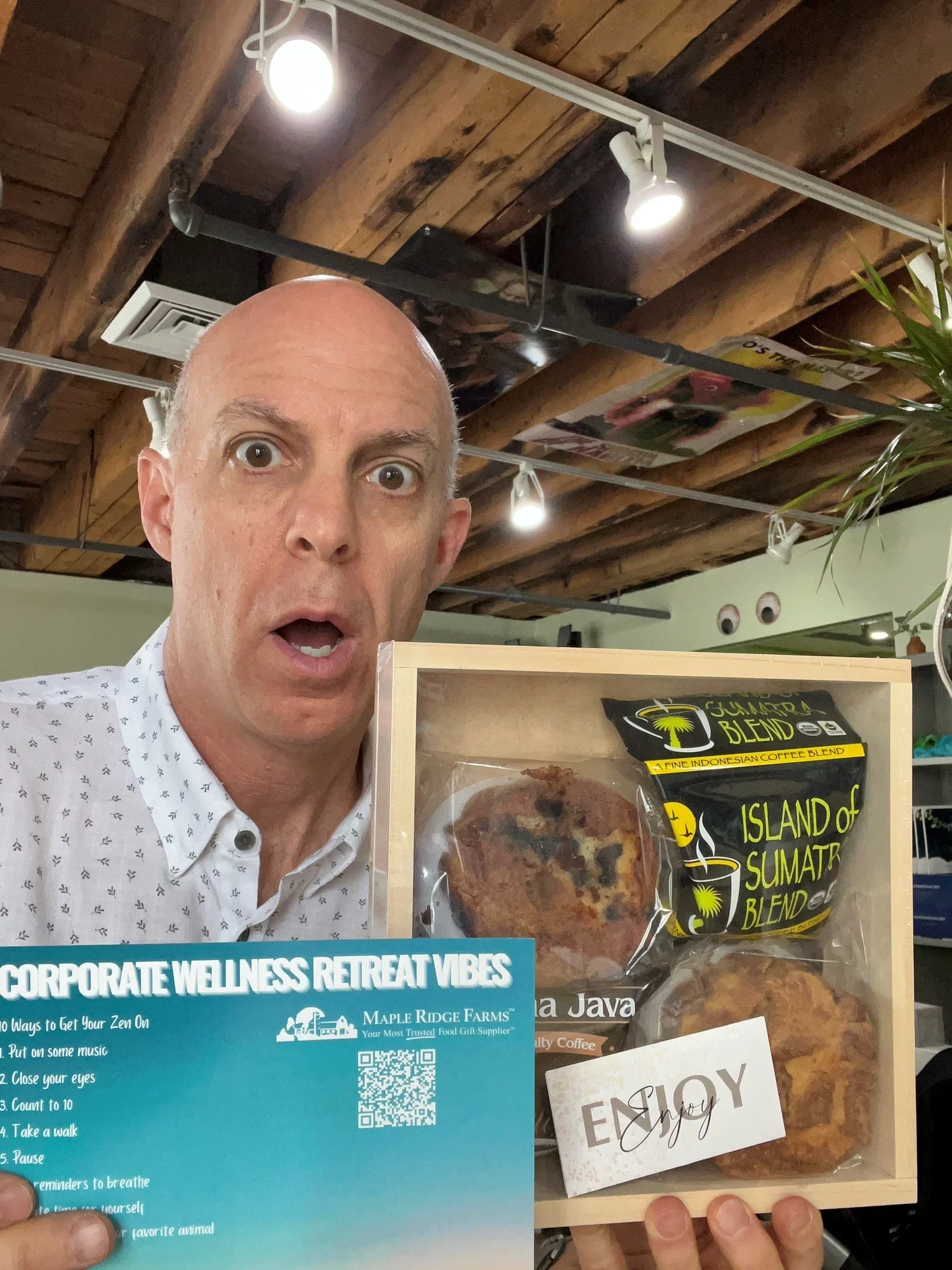 Image of a sustainable wooden tray branded with a company logo, packed with coffee cakes and artisan coffee, promoting a warm and engaging experience for remote employees.