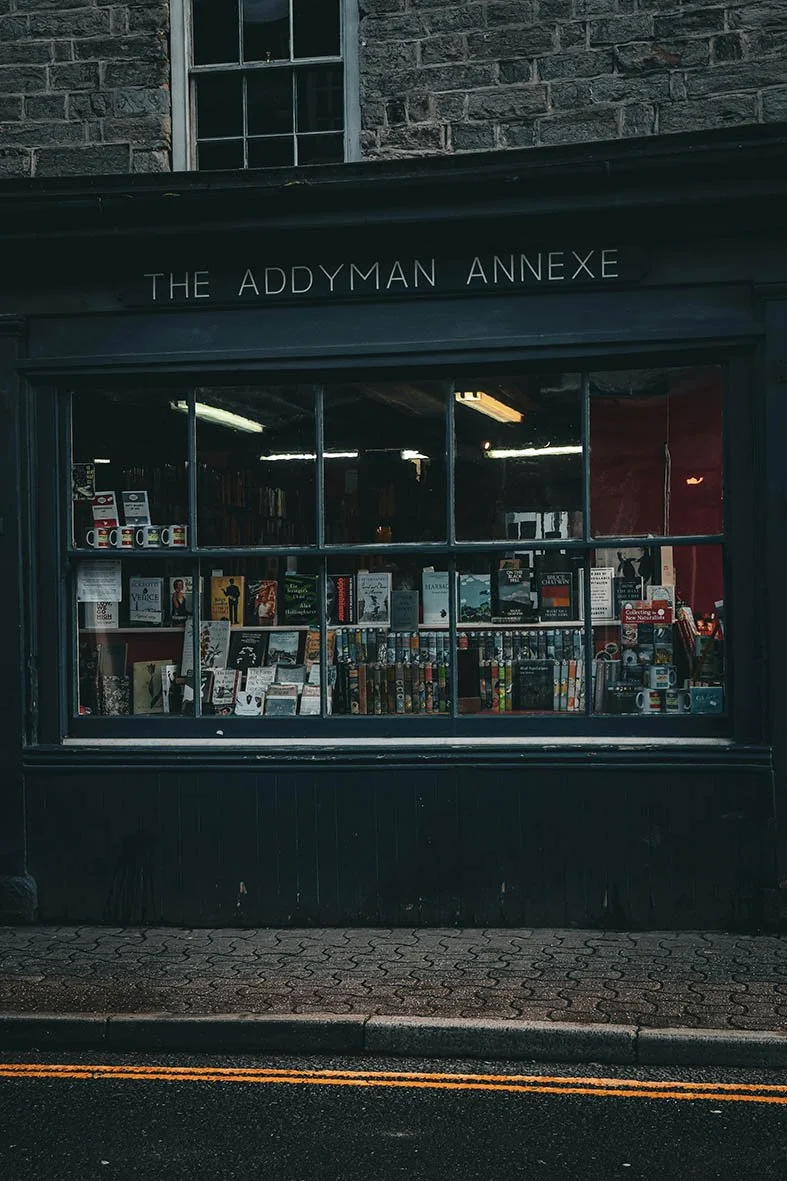 Exterior of a bookstore called The Addyman Annexe with books displayed inside the window.