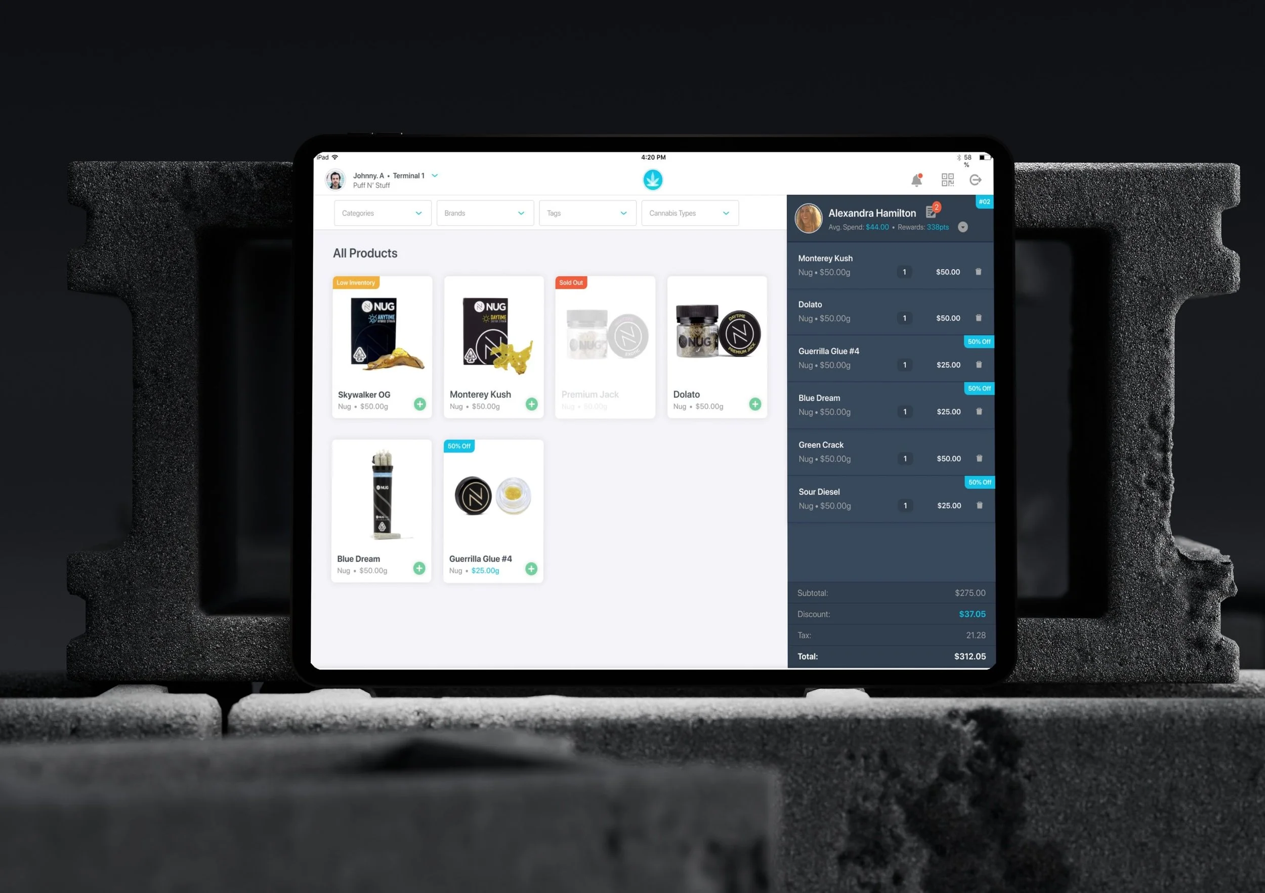 Tablet displaying a cannabis product listing and purchase summary, placed on concrete blocks.