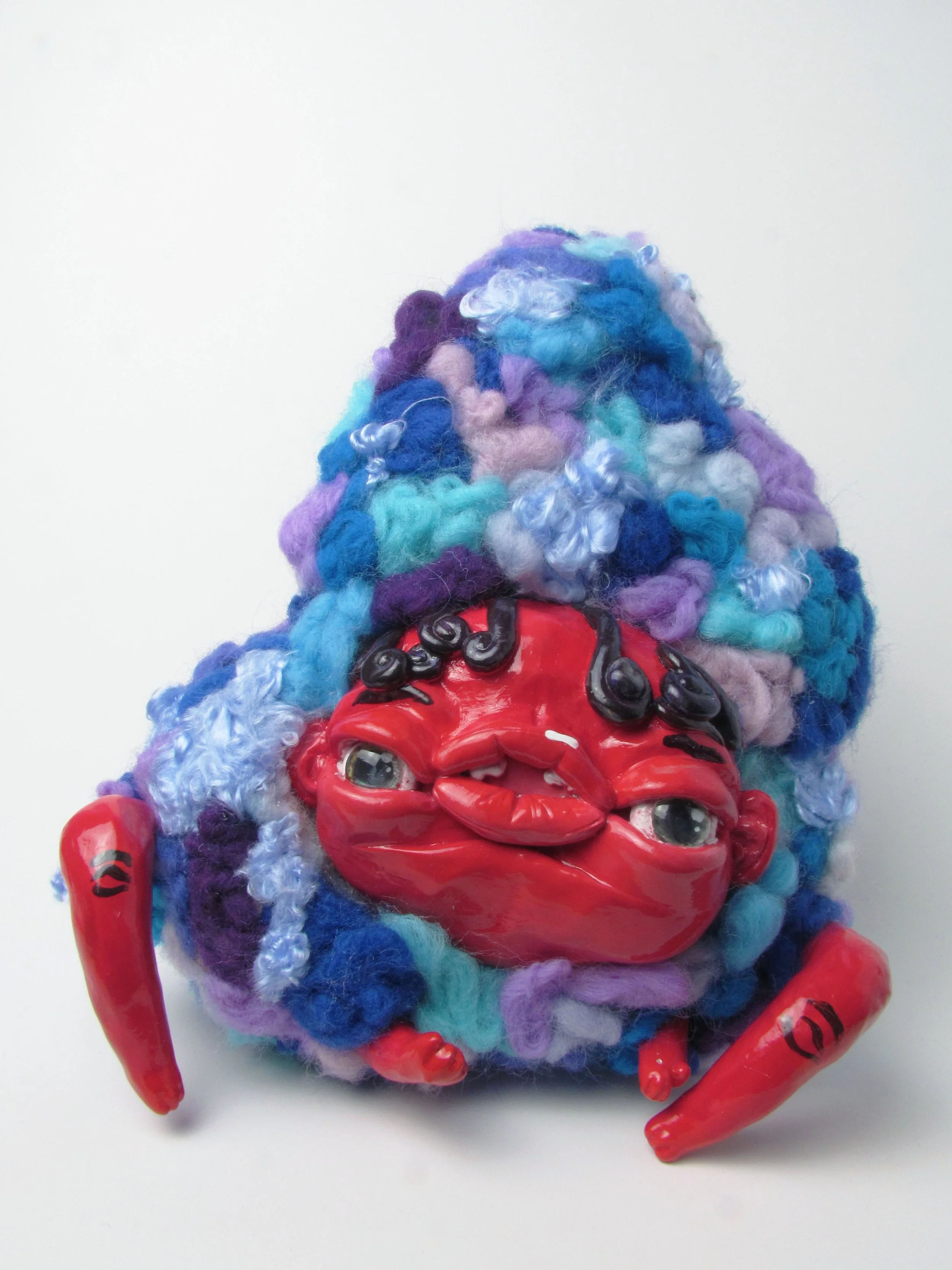 Red creature in blue.

Polymer clay, dyed wool, wire, beads, acrylic paint 
19 x 18 x 12 cm
2024
