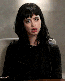 a woman dressed all inb black, rolling her eyes so hard that her head drops in despair