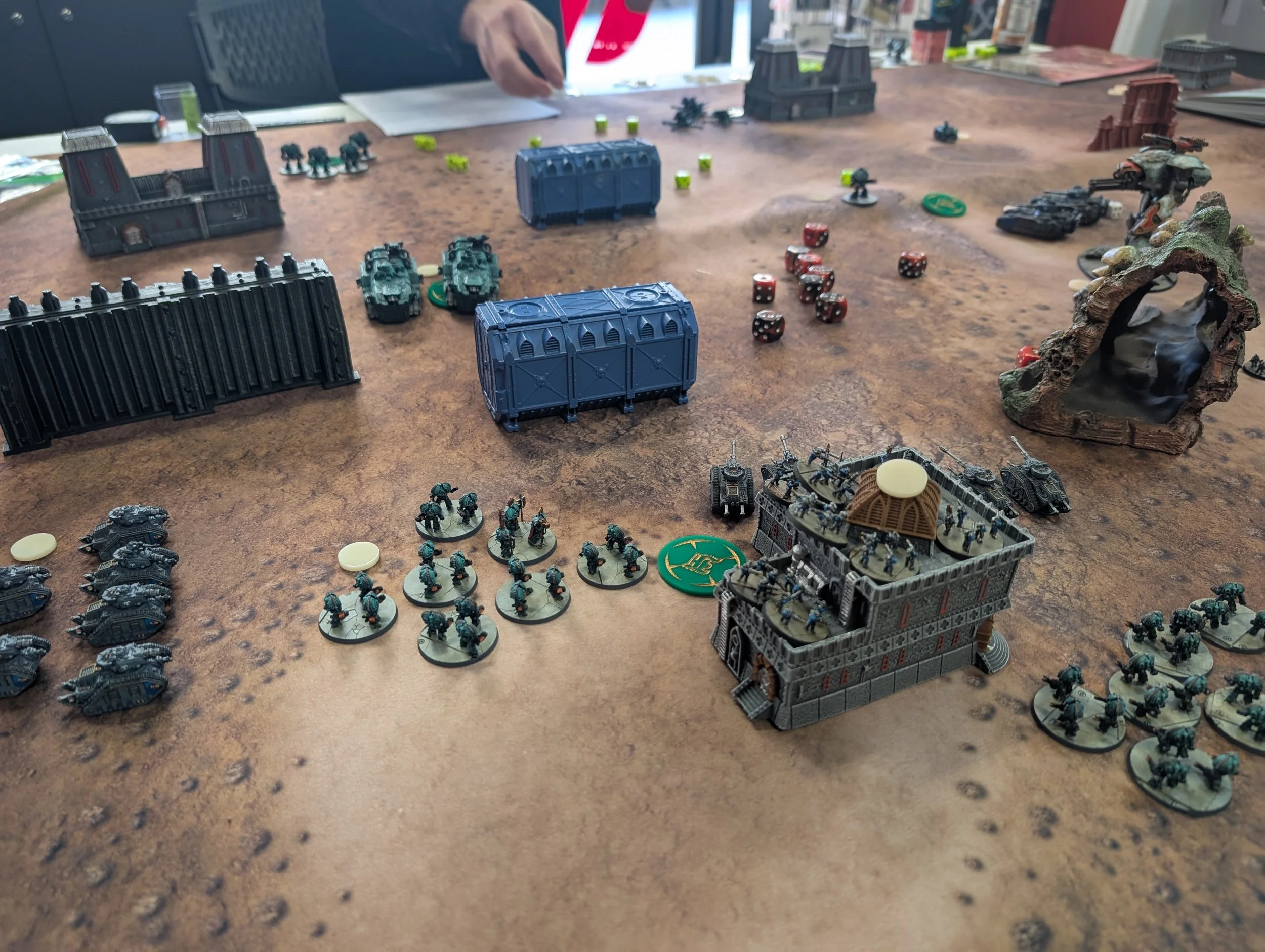 A handful of tanks and infantry stands face off in the foreground of a Legions Imperialis game