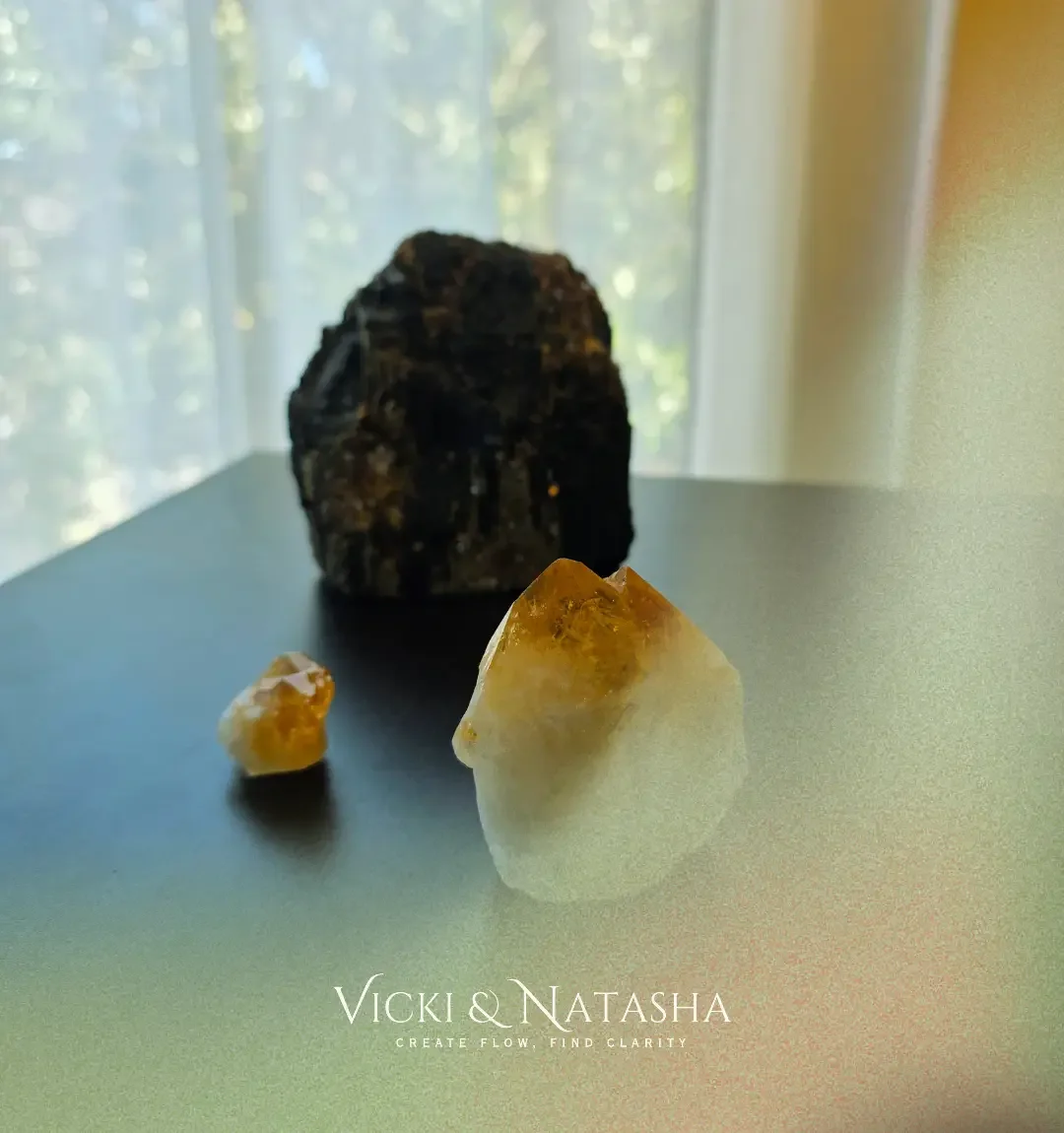 Two golden tourmaline crystals and a large black tourmaline known as Tommy, photographed in the sunlight at Vicki and Natasha’s home.
