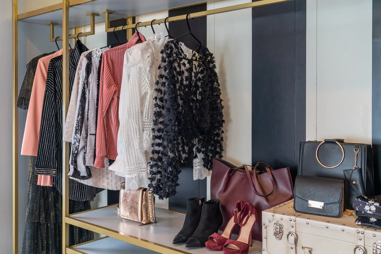 Curated clothing rack and shoes set up for personal shopping and wardrobe styling.