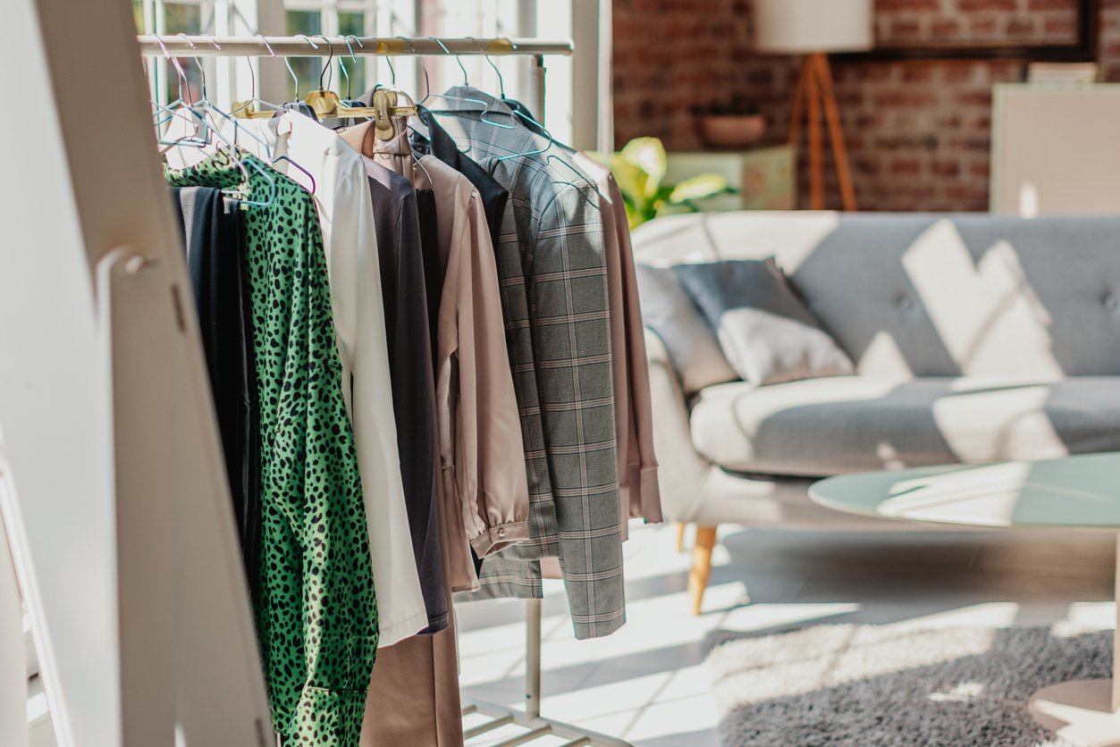 Curated outfits on a clothing rack with boots and heels for personal shopping and styling.