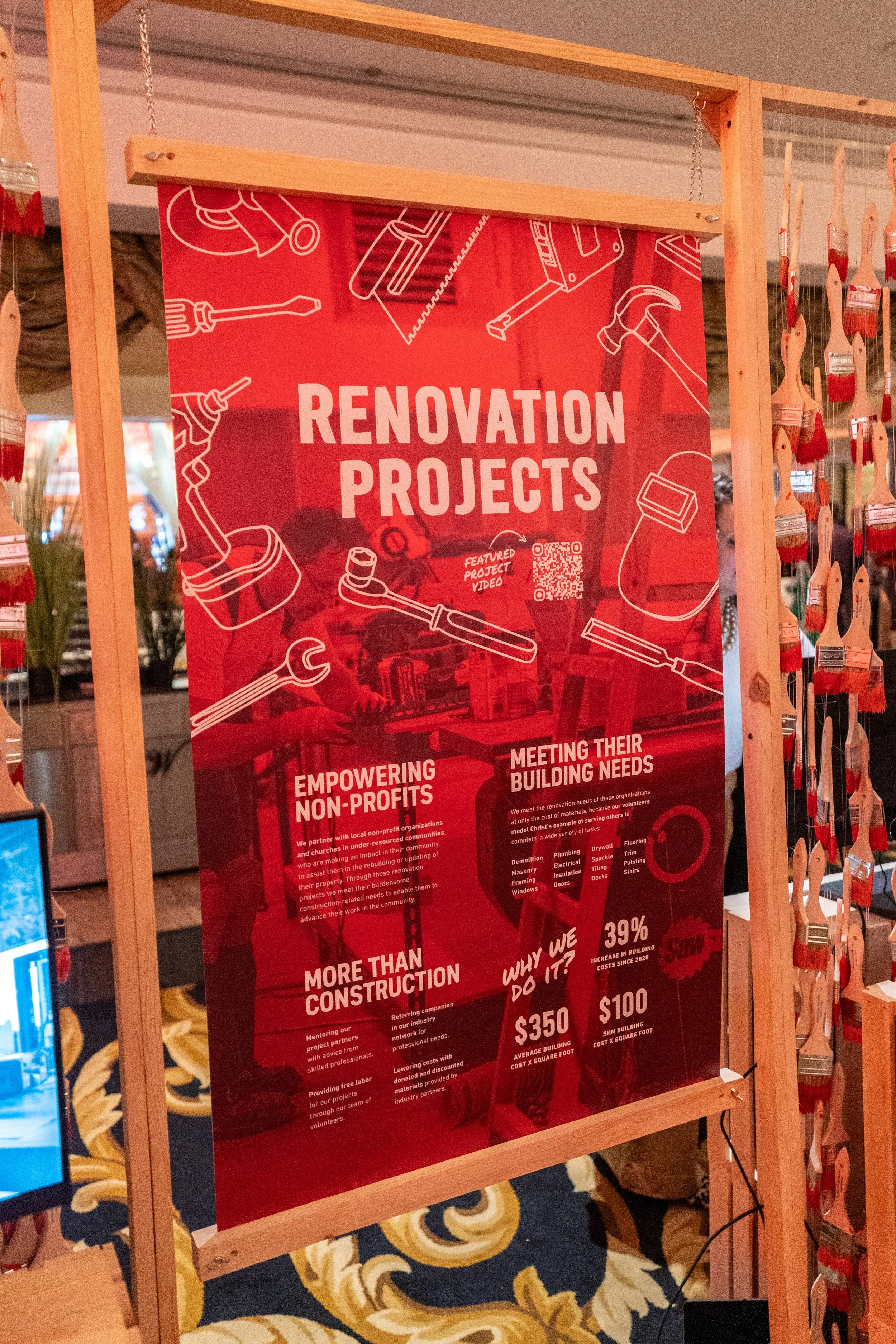 Red poster advertising renovation projects, featuring sketches of tools, QR code, and statistics about costs and benefits.