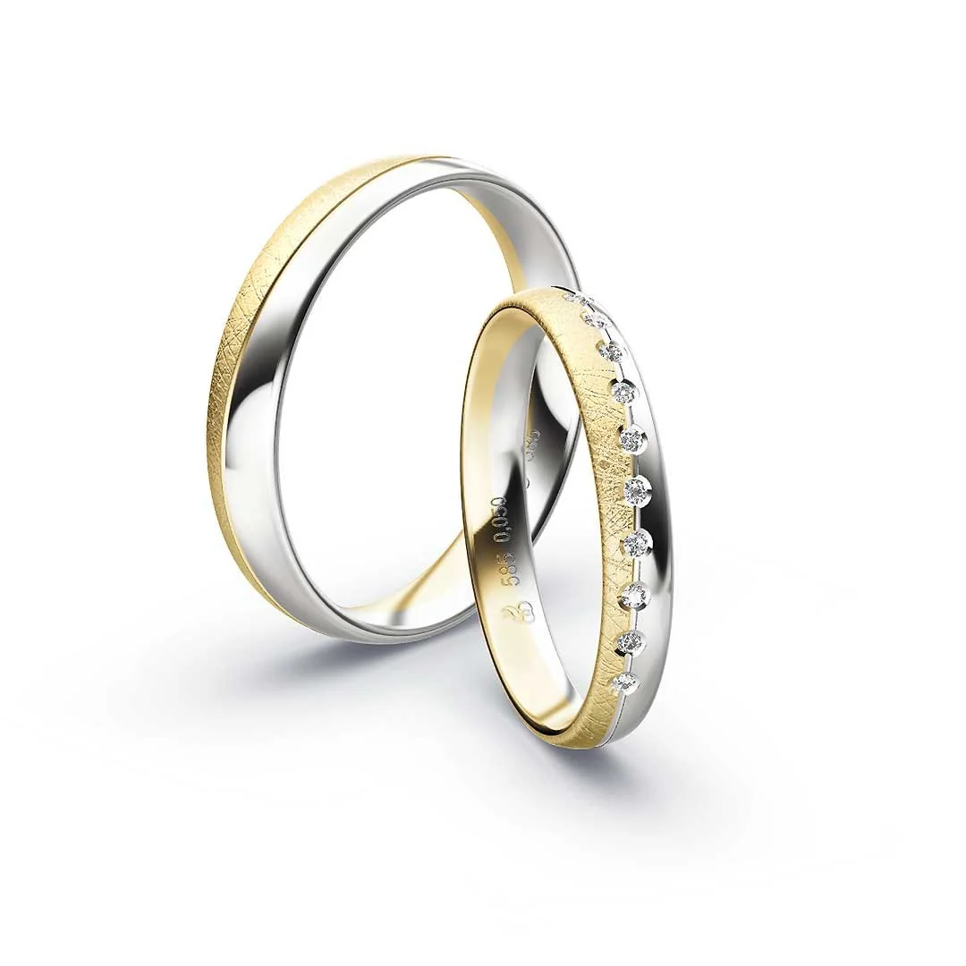 Zwei Trauringe, eines mit Diamanten, aus Silber und Gold, auf weißem Hintergrund.