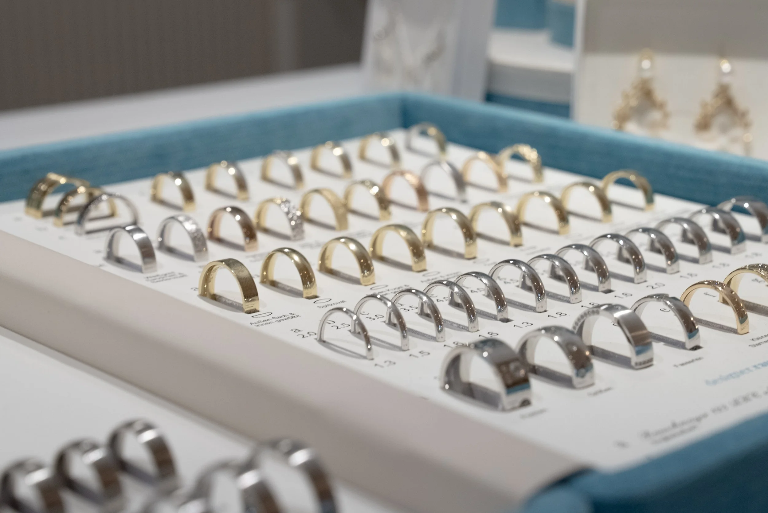 Verschiedene Ringe aus Gold, Silber und Edelstahl in einer Schmuckdisplay-Box.