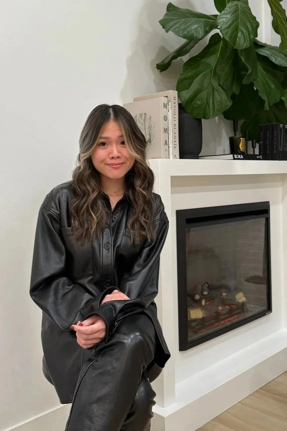 Gia Vu, Chicago hair colorist sitting at 821 West Salon in Chicago, IL with a smile